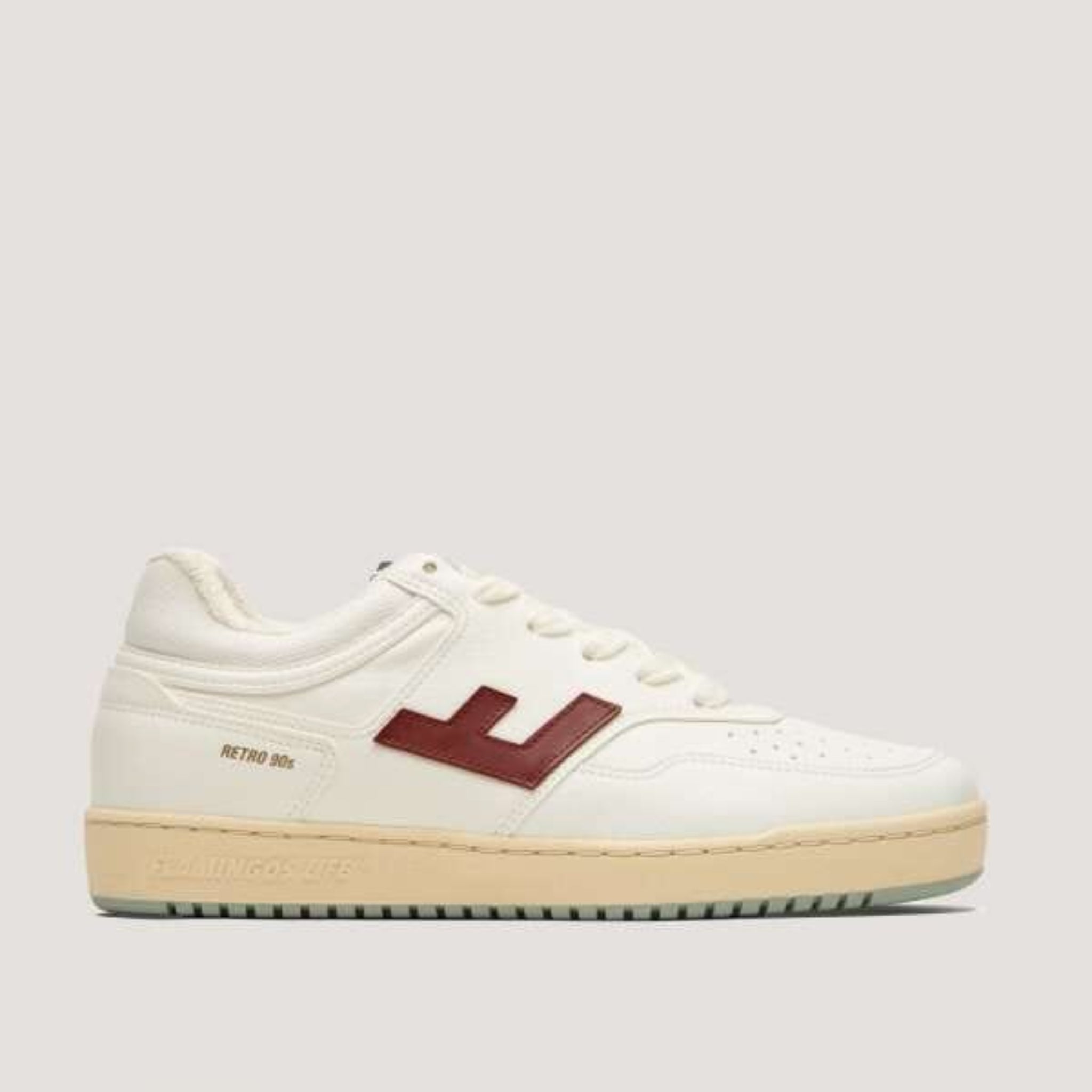 Weißer Sneaker mit beigem Sohlendetail und rotem Logo auf der Seite, im Retro-Design der 90er Jahre.