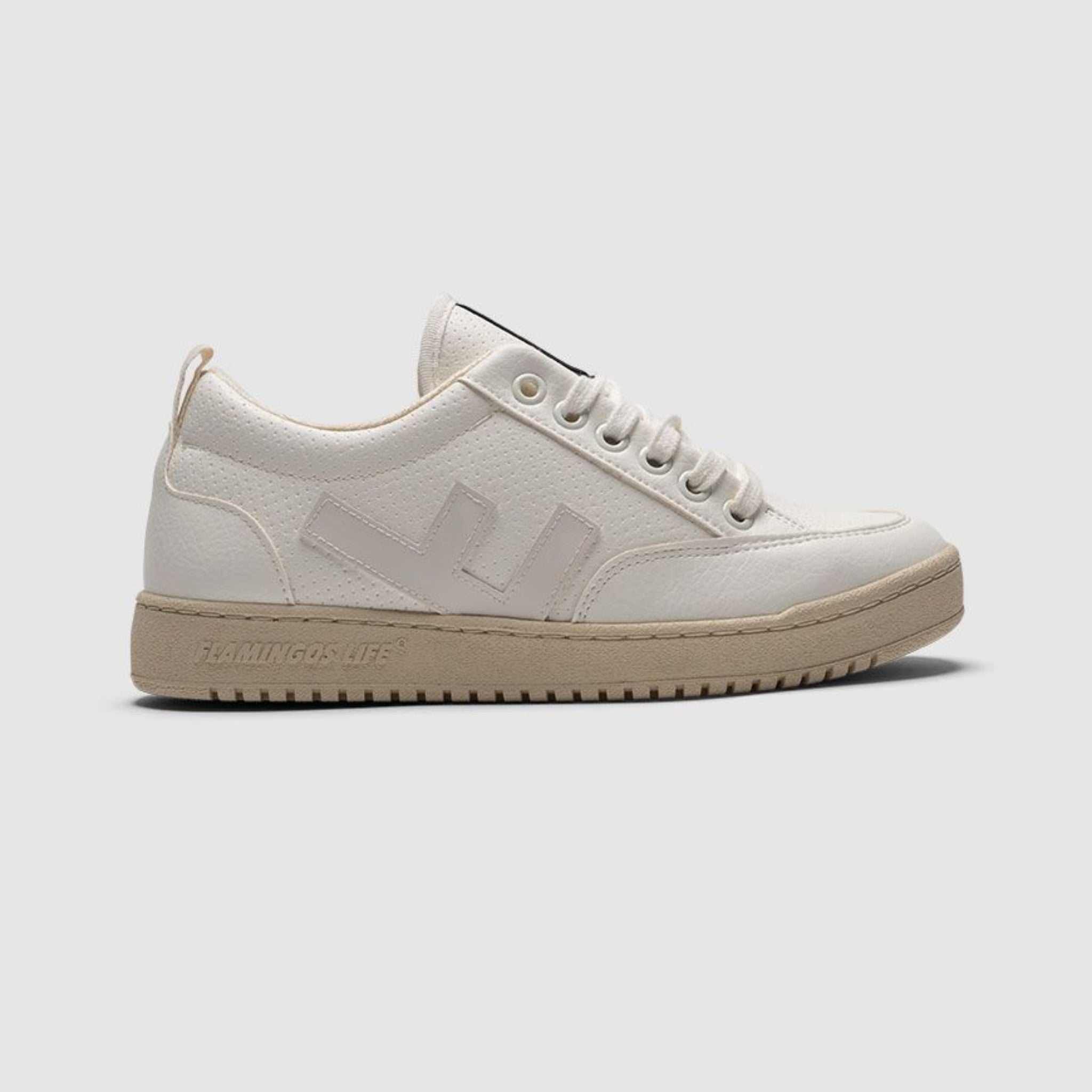 Weißer Sneaker mit dezenter Naht, beige Sohle und Schnürsenkeln auf grauem Hintergrund.