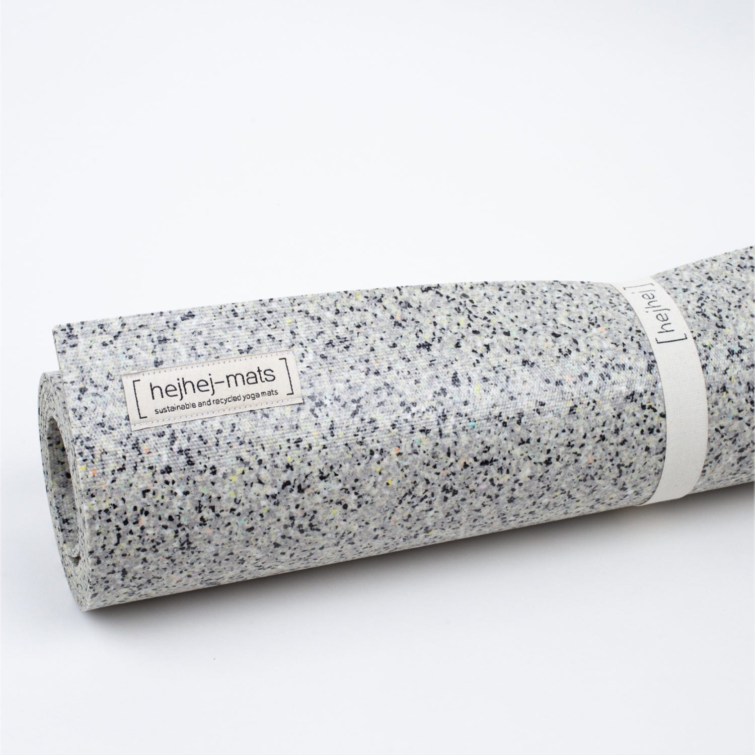 Gerollte Yogamatte aus recyceltem Material mit weiß-schwarzem Muster und Etikett "hejhej-mats".