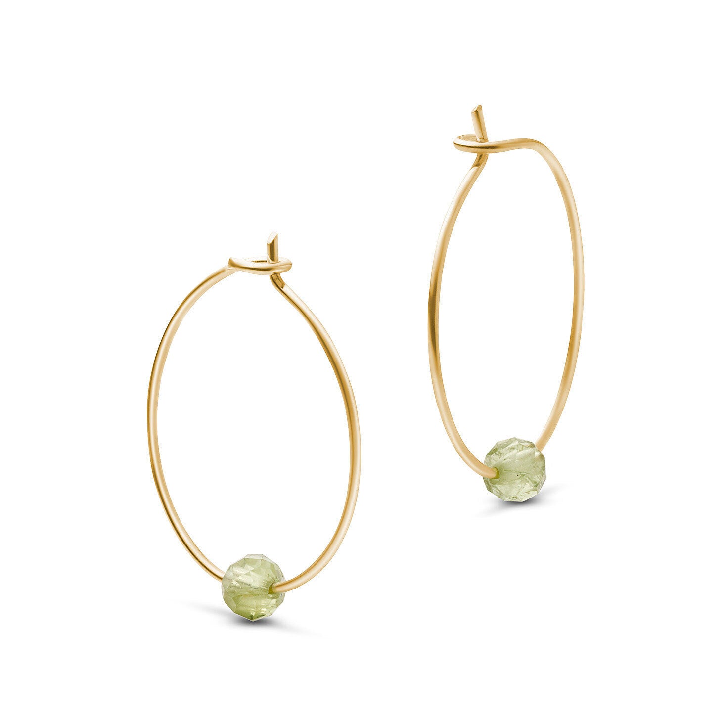 Goldene Creolen mit grünen Perlen entlang der Unterseite, freigestellt auf weißem Hintergrund.