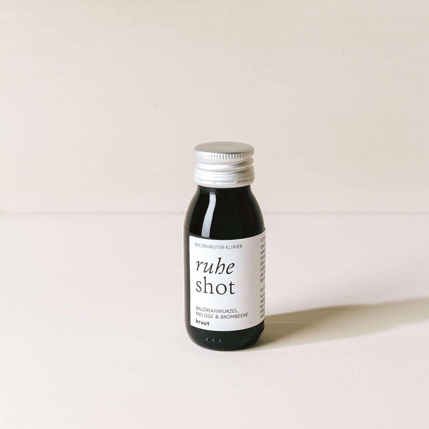 Kleine Flasche mit der Aufschrift "ruhe shot" auf einem weißen Hintergrund.
