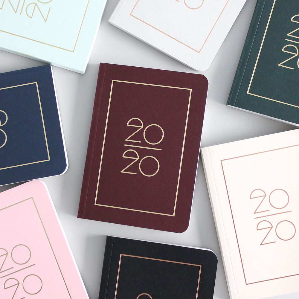 Mehrere buntfarbene Notizbücher mit der Aufschrift "2020" in goldener Schrift auf den Covern.