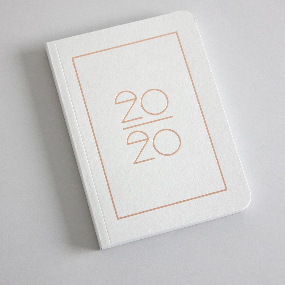 Weiße Notizbuchabdeckung mit der Jahreszahl "2020" in minimalistischer Schrift und einem rechteckigen Rahmen.