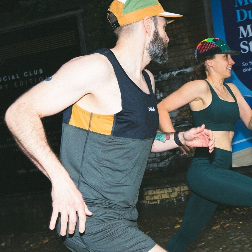 Ein Mann und eine Frau joggen gemeinsam in sportlicher Kleidung und Mützen im Freien.