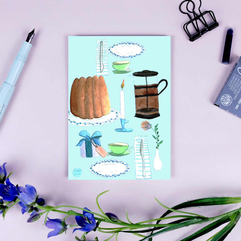 Karte mit Illustrationen von Kuchen, Kaffee, Kerze, Geschirr und Blumen auf türkisfarbenem Hintergrund, umgeben von Büroklammern und Blumen.
