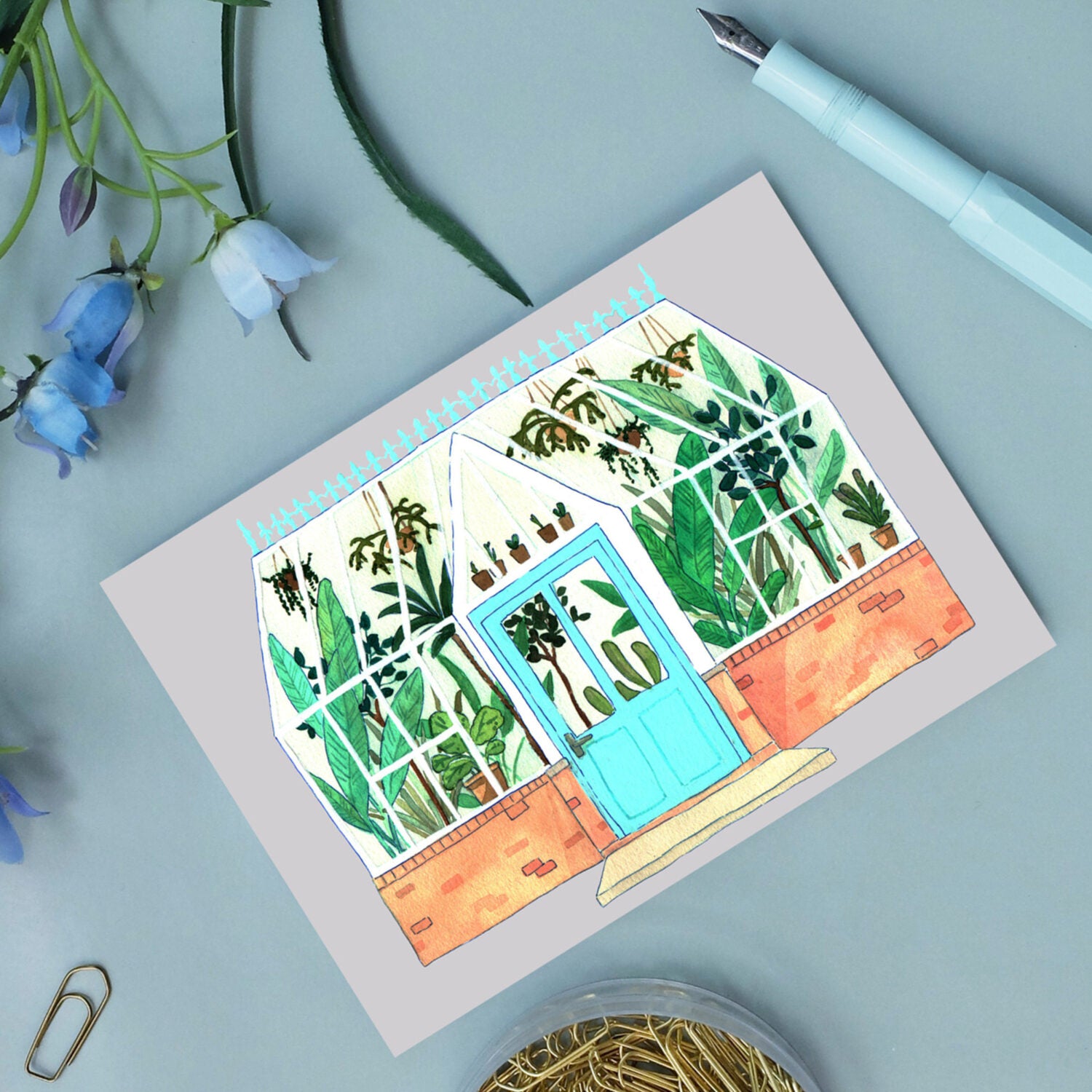 Illustration eines Gewächshauses mit vielen grünen Pflanzen, umgeben von blauen Blumen und einem türkisfarbenen Füllfederhalter.