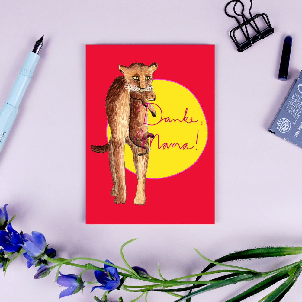 Illustration einer Löwenmutter mit Jungem vor rotem Hintergrund und gelber Sonne, daneben steht "Danke, Mama!".