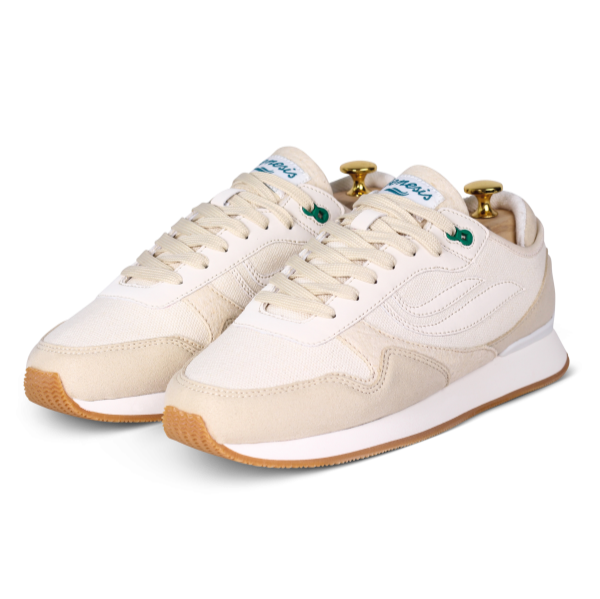 Beige Sneaker mit weißer Sohle und grünen Akzenten, präsentiert auf einem weißen Hintergrund.