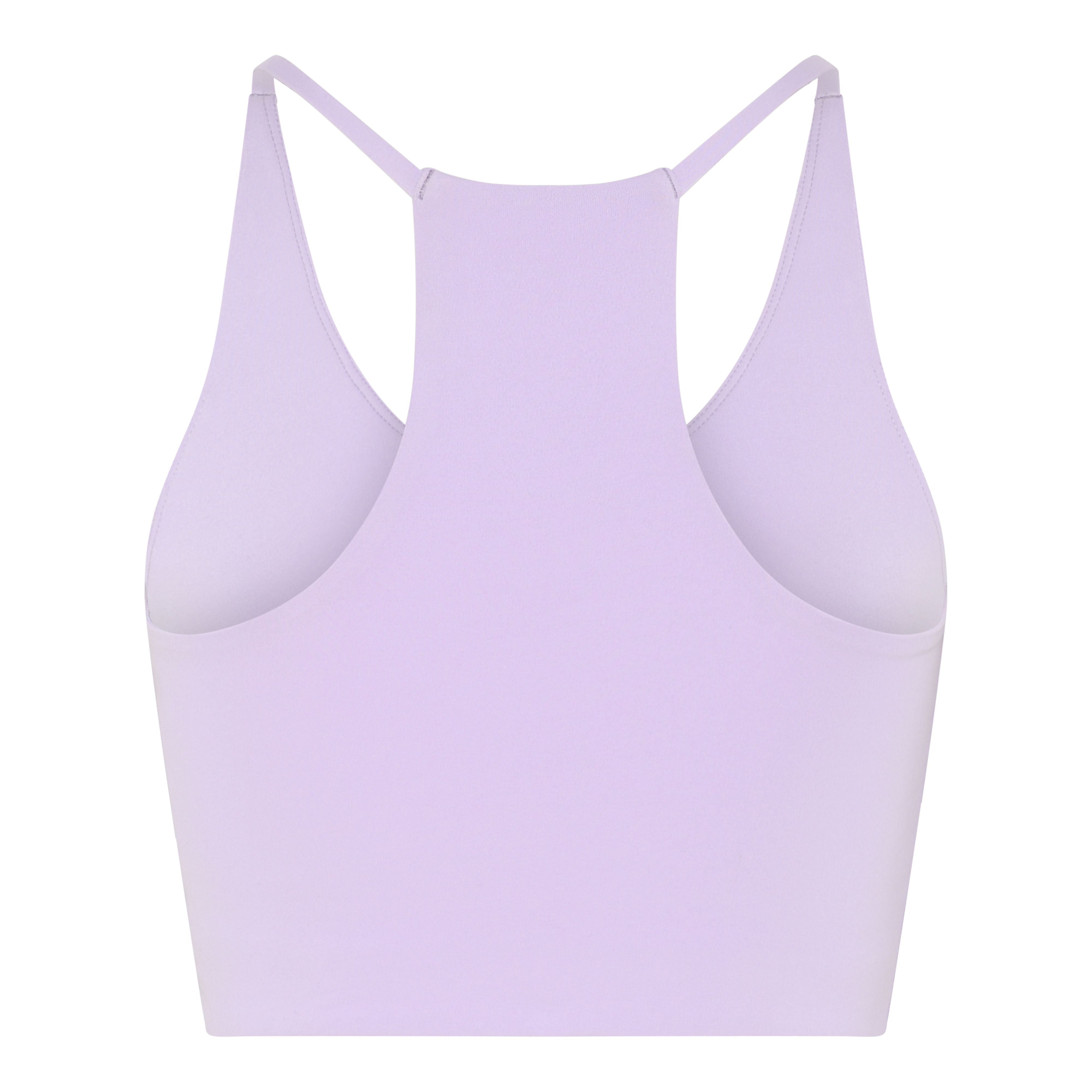 Ein lavendelfarbener Racerback-Sport-BH ist von hinten vor einem weißen Hintergrund abgebildet. Der BH hat ein glattes, nahtloses Design mit breiten Seitenteilen und dünnen Schulterträgern.