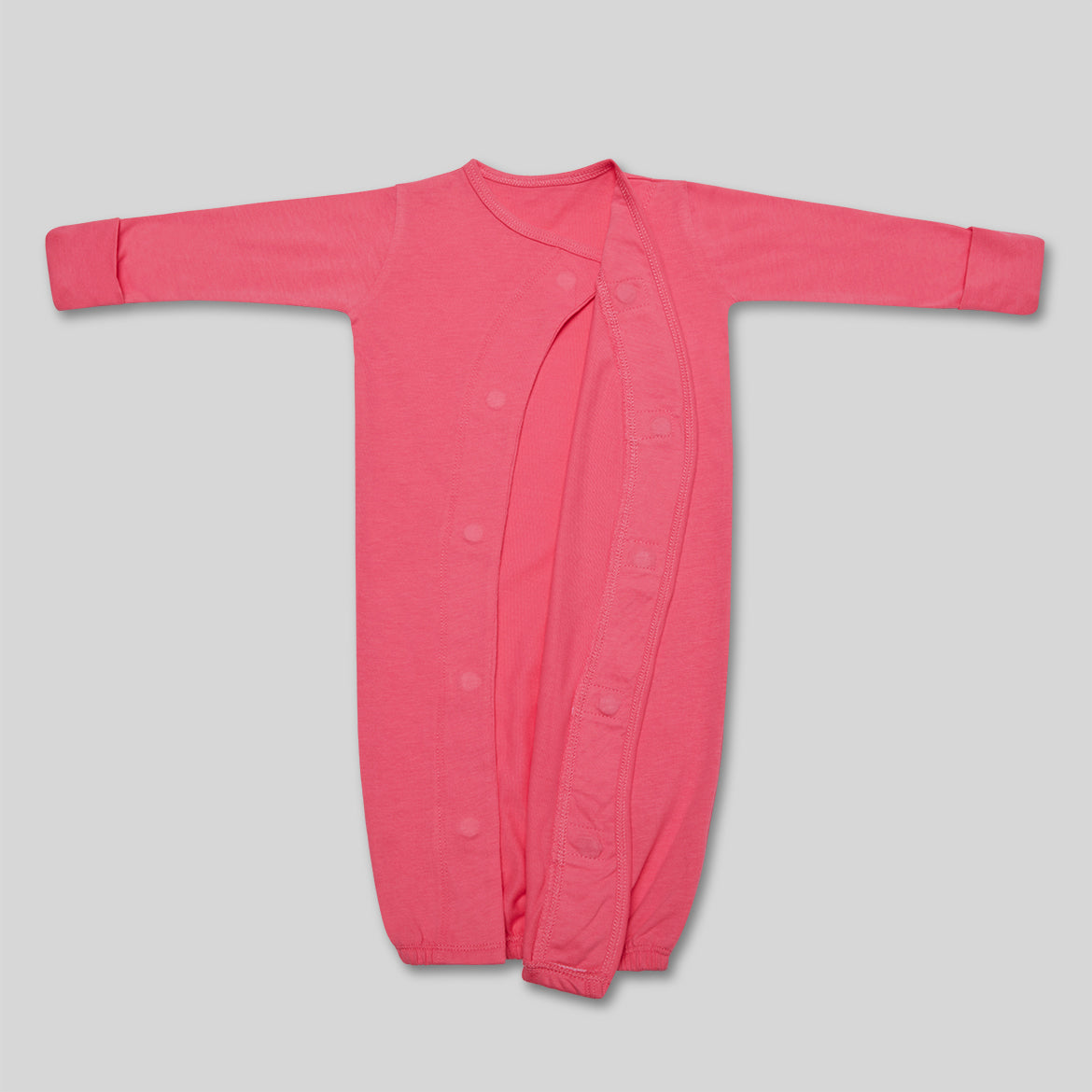 Langärmeliger, pinker Baby-Schlafsack mit Knöpfen auf einem hellgrauen Hintergrund.