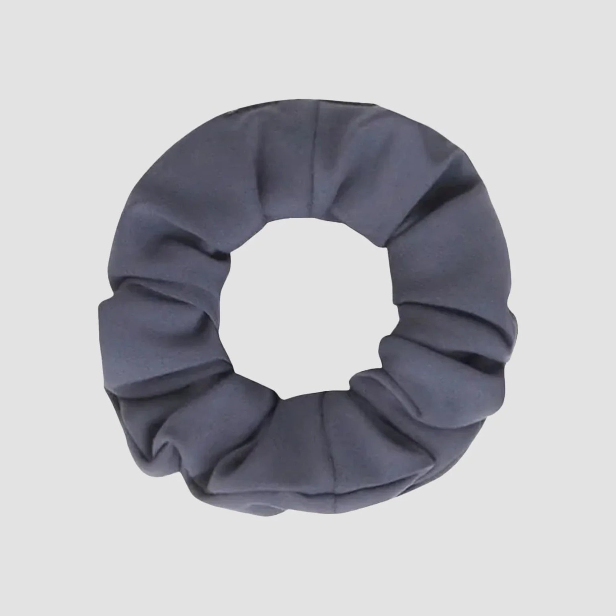 Ein dunkelgraues Haargummi aus Stoff mit weicher, geraffter Textur, das auf einem schlichten hellen Hintergrund abgebildet ist.
