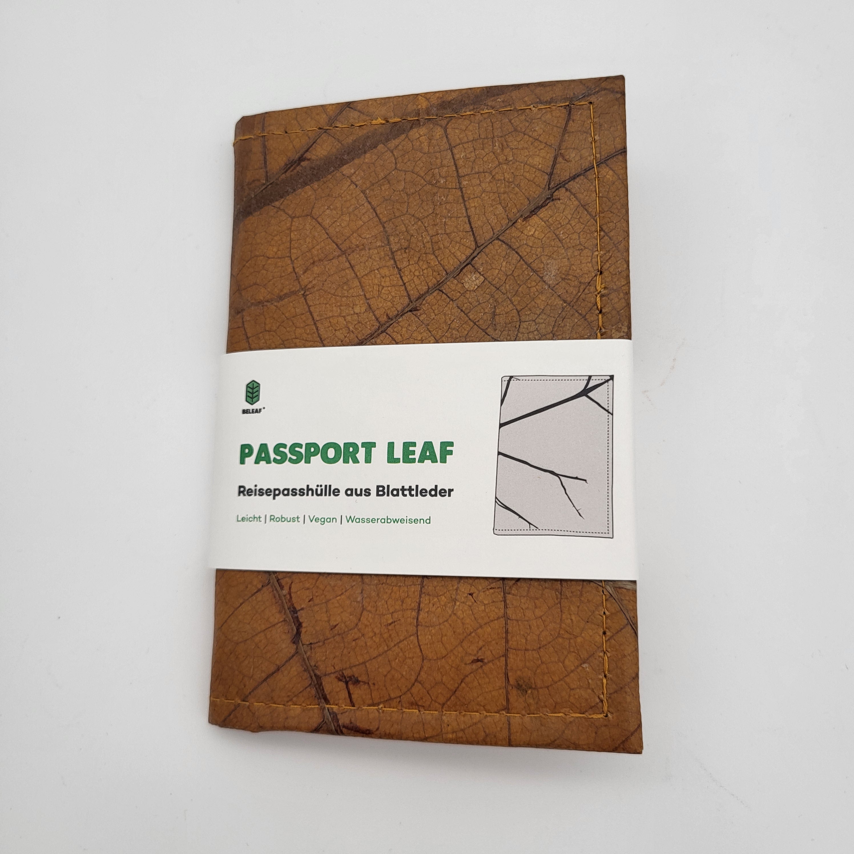 Ein brauner Reisepasshalter aus Leder mit sichtbaren Blattadern. Es hat ein weißes Etikett mit der Aufschrift PASSPORT LEAF und wird als vegan, robust, leicht und wasserabweisend beschrieben.