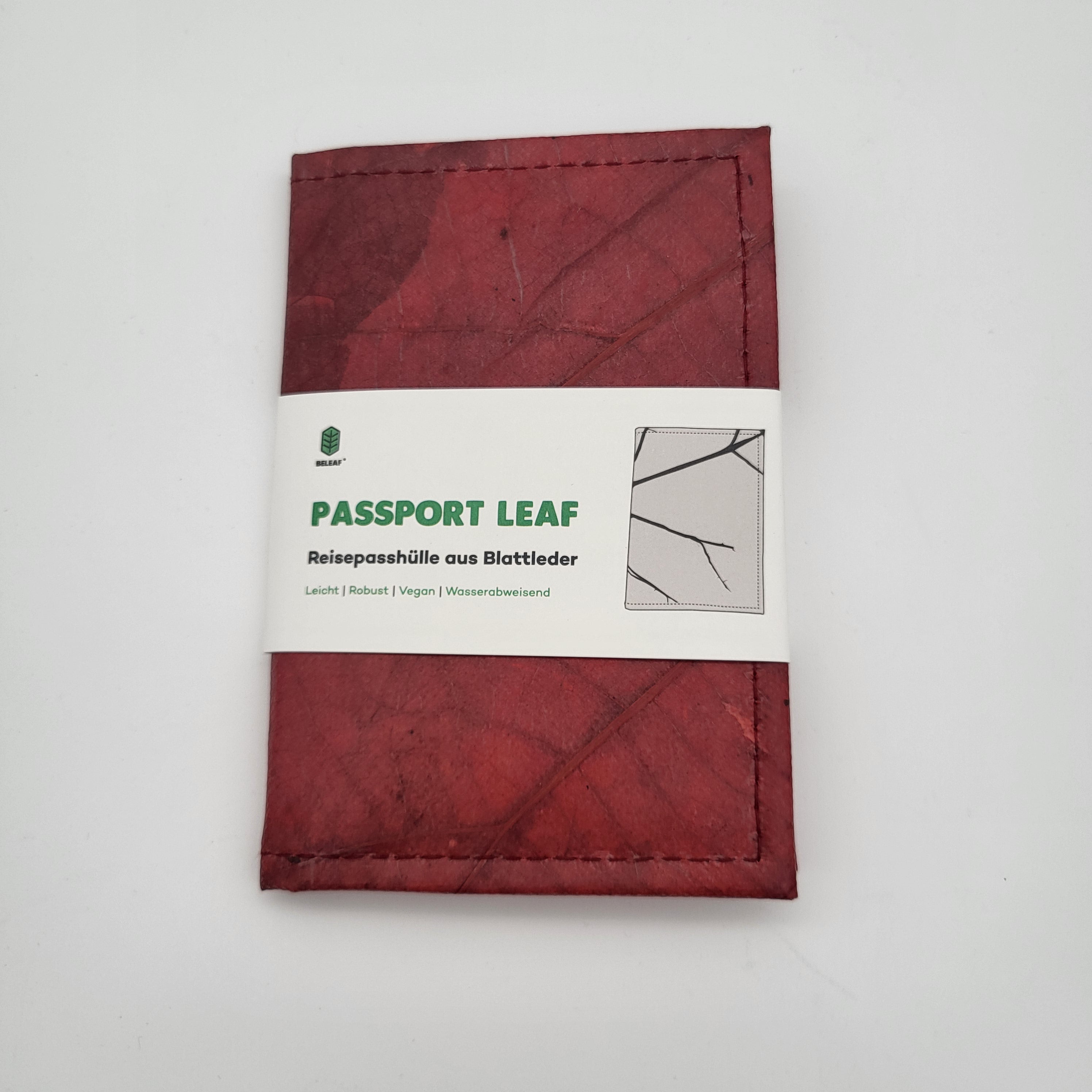 Ein roter Reisepasshalter mit Blattstruktur und einem weißen Etikett mit der Aufschrift PASSPORT LEAF und Reisepasshülle aus Blattleder sowie Symbolen und Text, die darauf hinweisen, dass er leicht, haltbar, vegan und wasserfest ist.