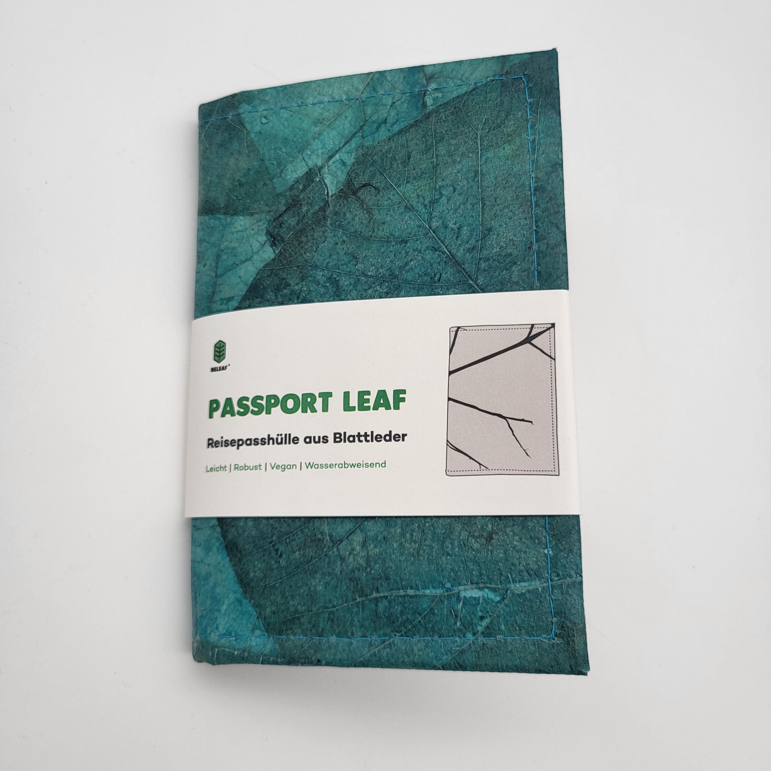 Eine tealfarbene Reisepasshülle aus Blattleder mit der Aufschrift PASSPORT LEAF. Die Verpackung enthält einen deutschen Text und eine Illustration der Textur der Hülle und betont, dass sie leicht, vegan und wasserfest ist.