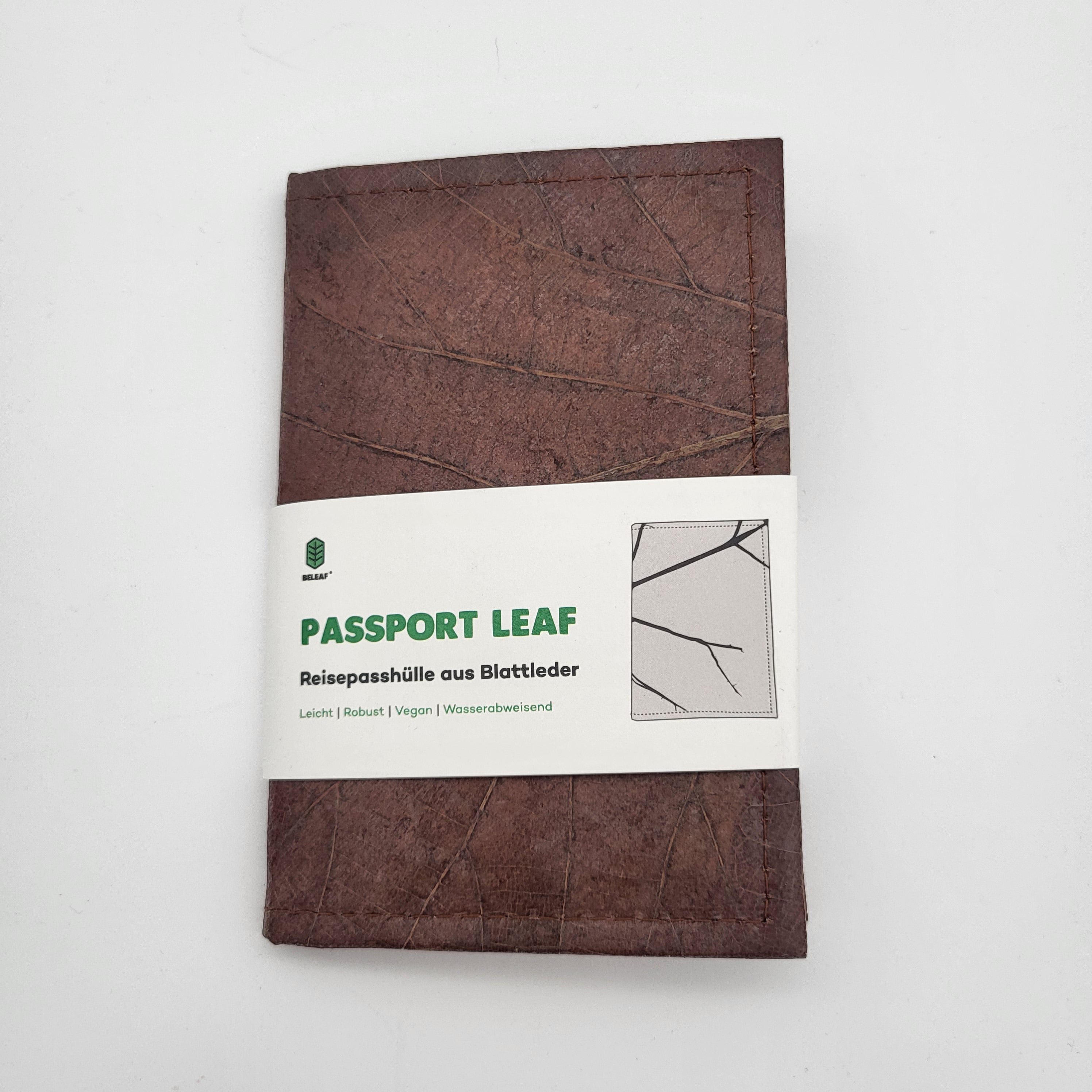Ein brauner Reisepasshalter mit einem sichtbaren Blattrippenmuster und der Aufschrift "Passport Leaf" auf einem weißen Papierband, hergestellt aus nachhaltigen Materialien. Das Produkt ist vor einem schlichten weißen Hintergrund abgebildet.