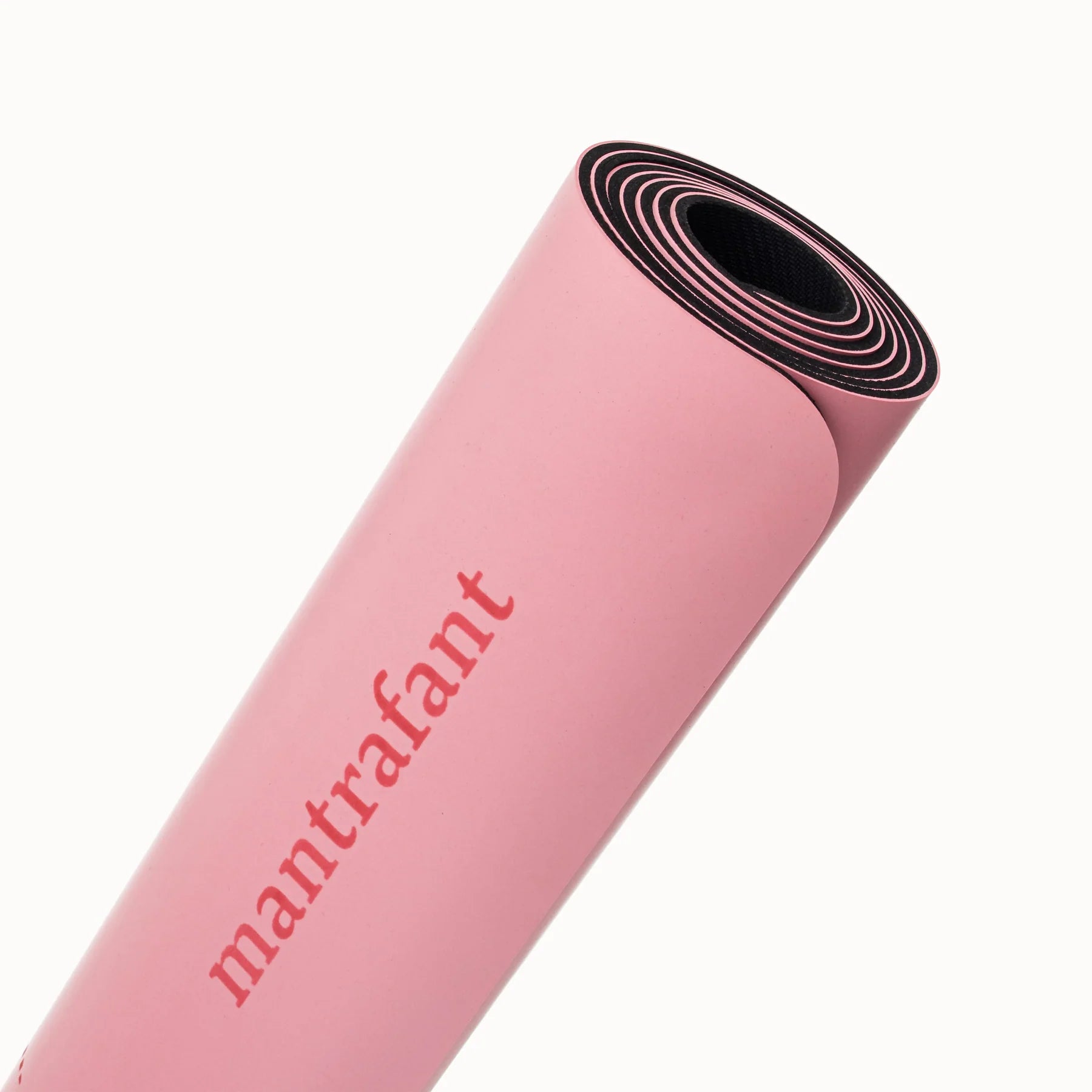 Gerollte pinke Yogamatte mit dem Schriftzug "mantrafant" auf der Oberfläche.