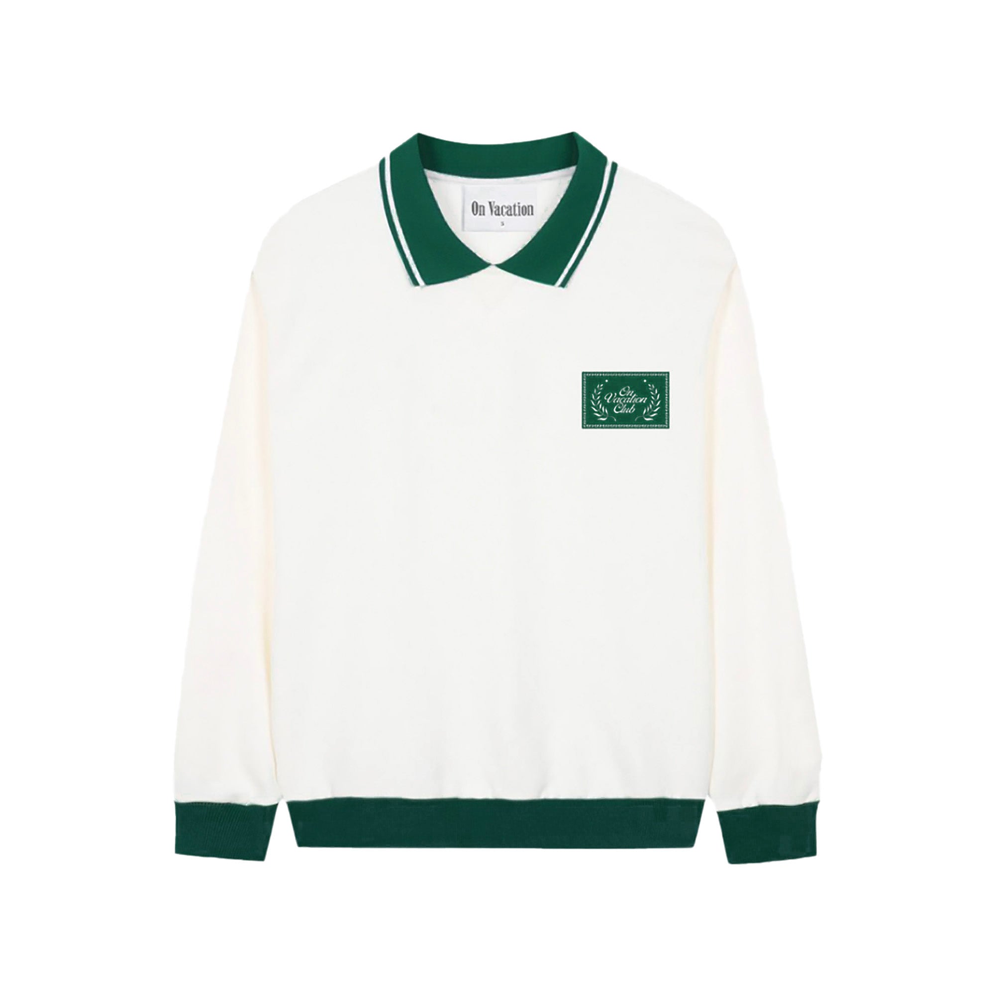 Ein weißes, langärmeliges Polo-Sweatshirt mit grünem Kragen, grünen Bündchen und grünem Saum. Auf der Brust befindet sich ein grüner Aufnäher mit einem Lorbeermuster und weißem Text. Auf dem Nackenschild steht On Vacation.