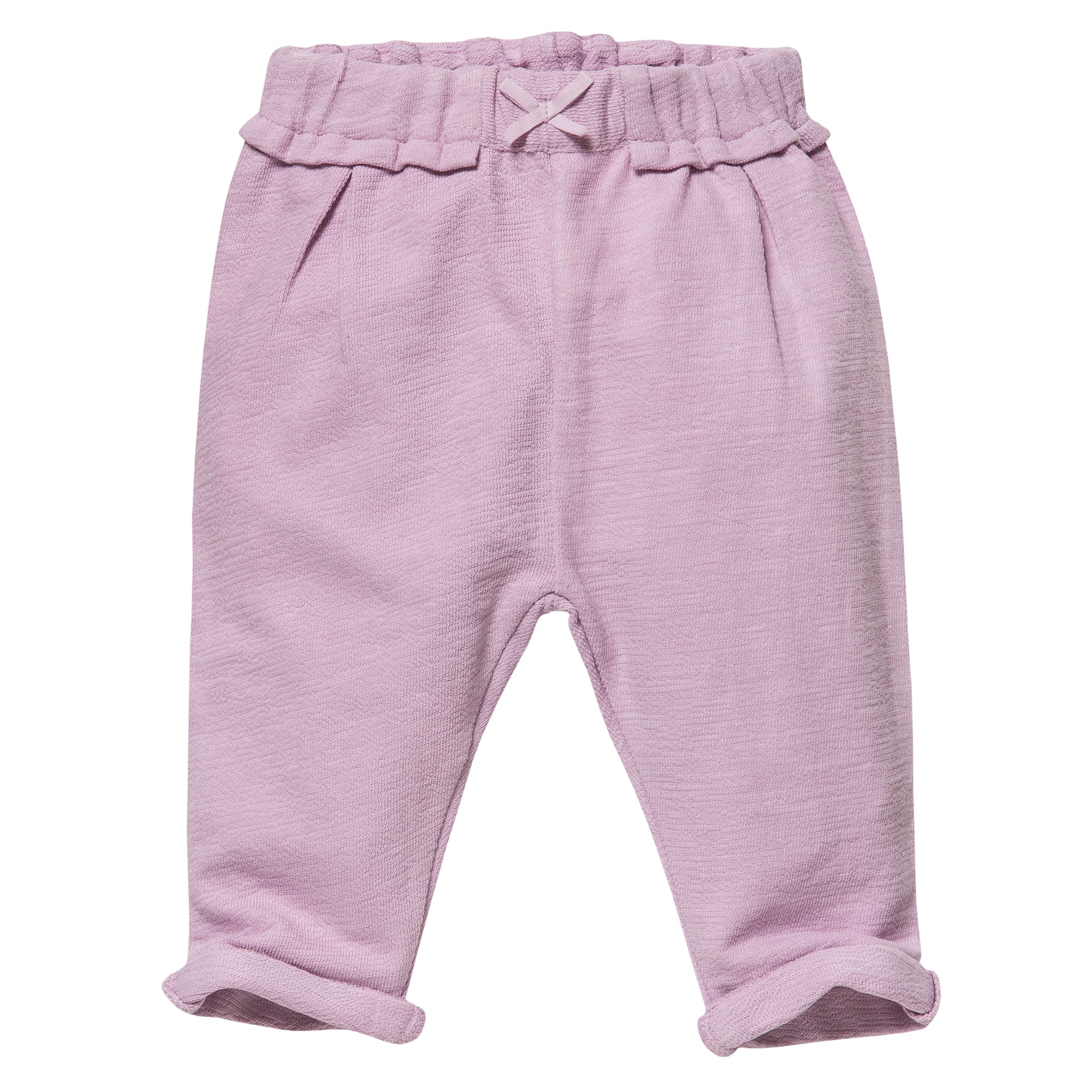 Hellrosa Babyhose mit elastischem Rüschenbund, kleiner Zierschleife auf der Vorderseite und aufgerollten Bündchen an den Knöcheln. Die Hose hat einen weichen, strukturierten Stoff und eine lockere Passform.