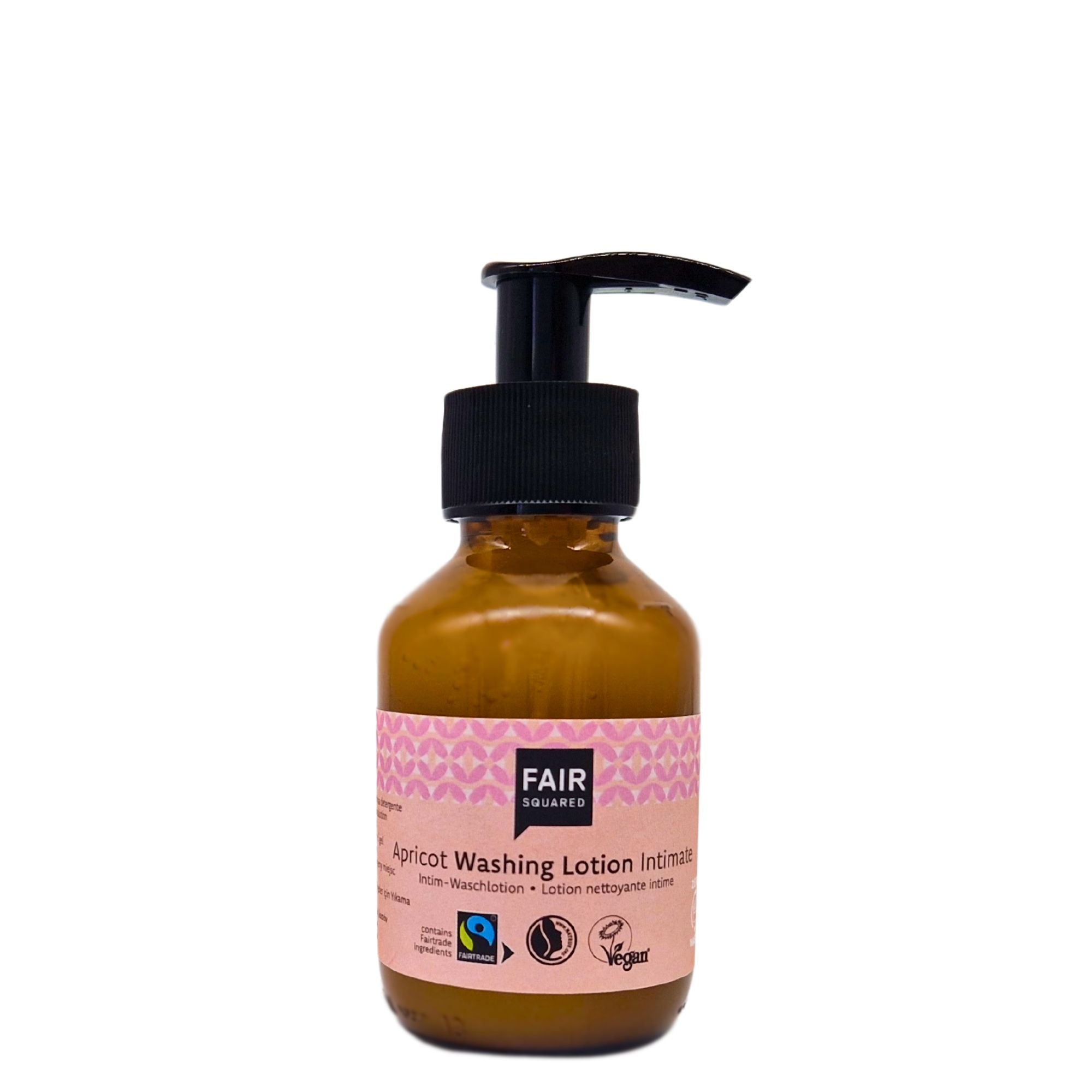 Eine braune Pumpflasche der Fair Squared Apricot Washing Lotion Intimate mit einem rosa-weißen Etikett mit verschiedenen Zertifizierungssymbolen, darunter Logos für Fairen Handel und Vegan, auf weißem Hintergrund.