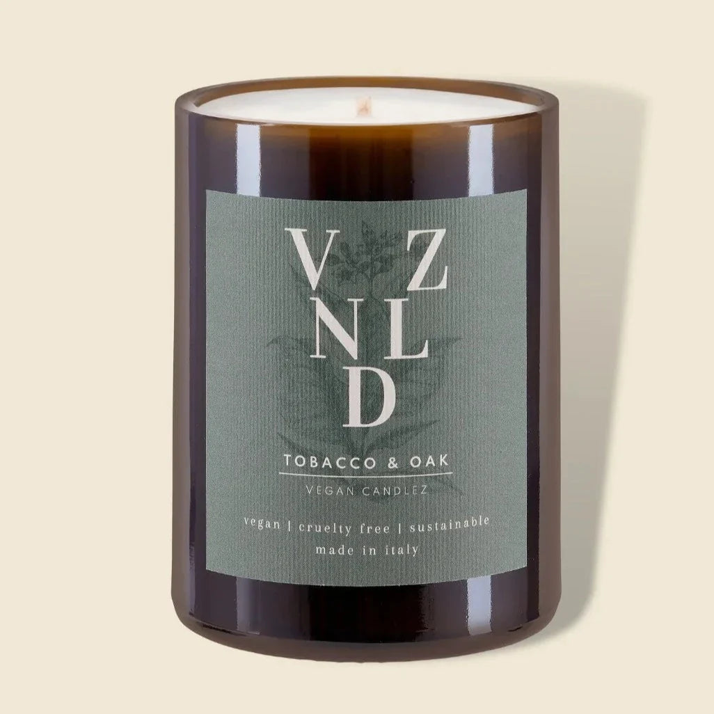 Braune Kerze mit grünem Etikett, auf dem "VZNL D" und "Tobacco & Oak" steht, vegan, grausamkeitsfrei und nachhaltig.