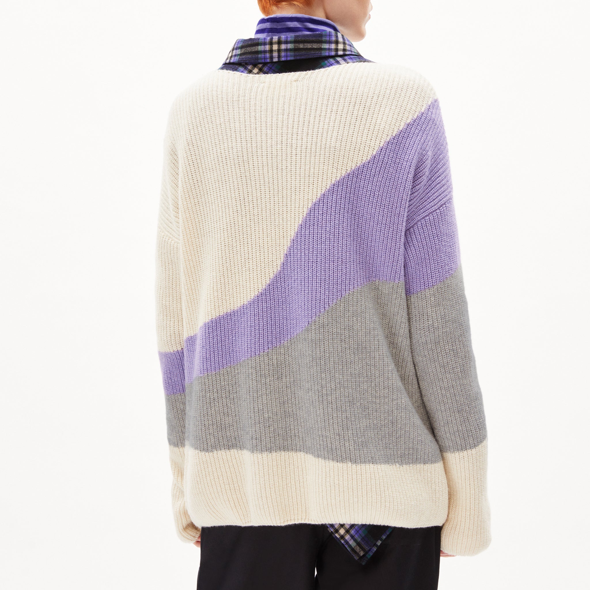Person in einem gestreiften Pullover in Beige, Lila und Grau von hinten, Kragen eines karierten Hemdes sichtbar.