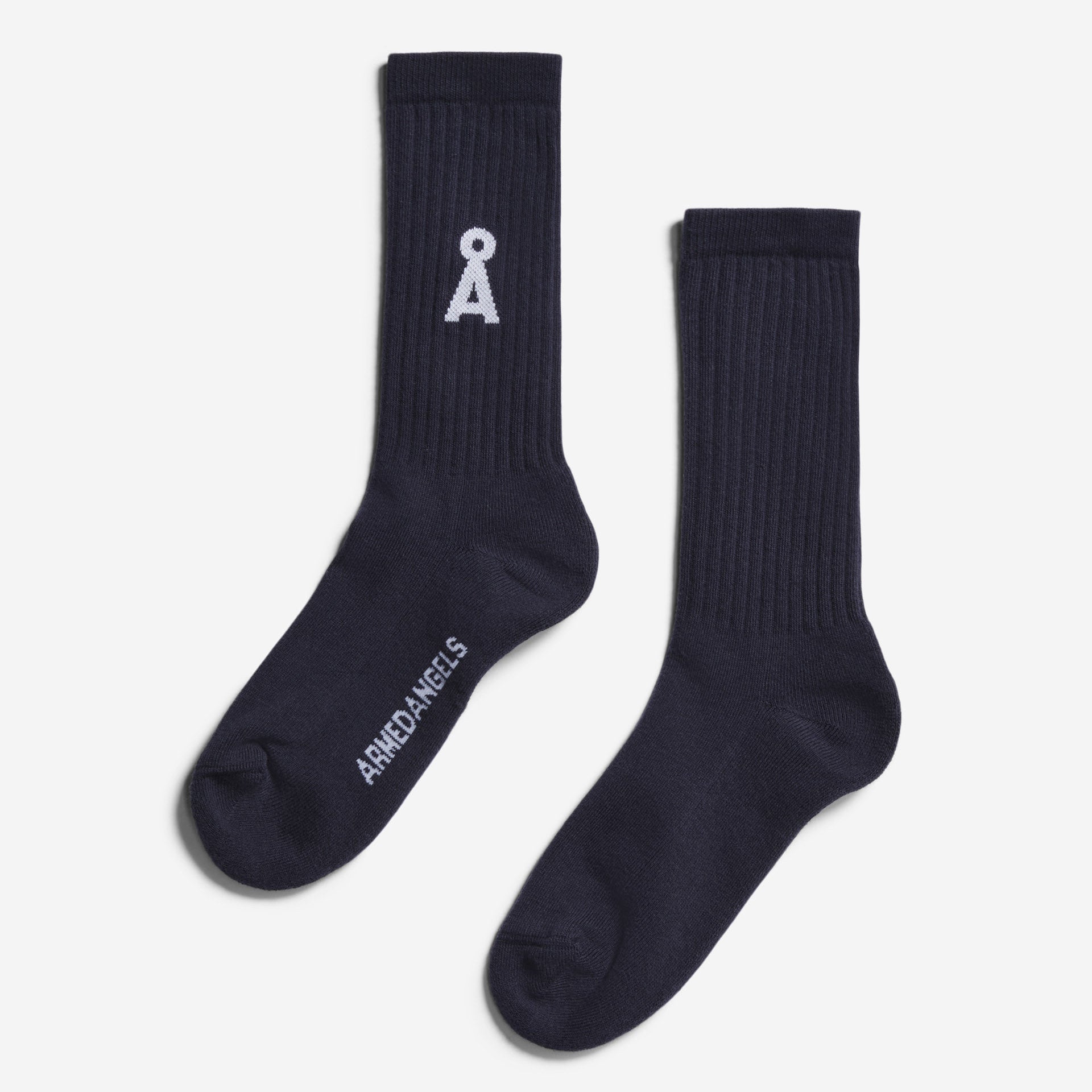 Ein Paar dunkle marineblaue Socken auf weißem Hintergrund. Eine Socke zeigt ein weißes abstraktes Logo in der Nähe der Spitze, und die andere hat das Wort ARMDAKIELS in weiß auf dem Fuß geschrieben.