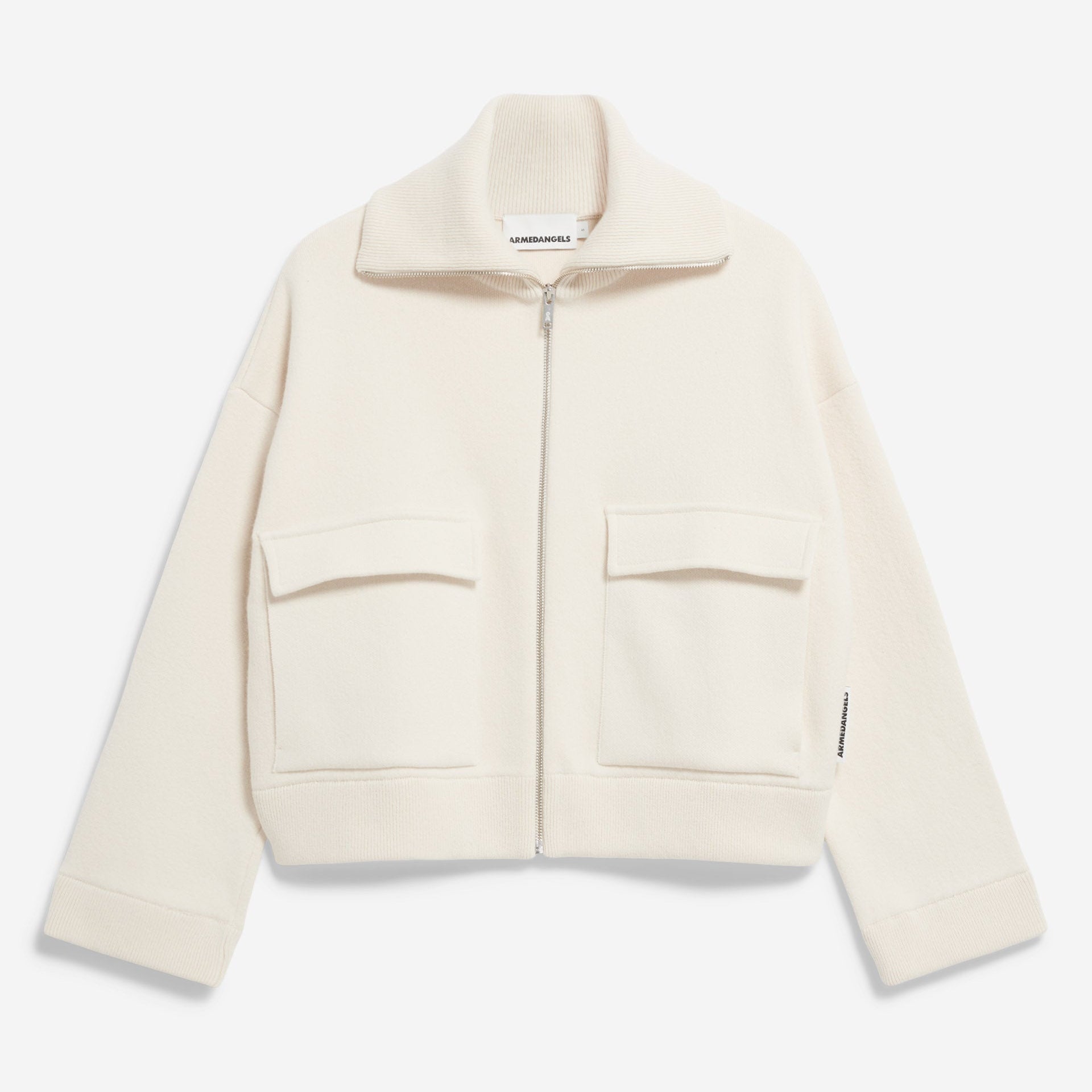 Eine cremefarbene, langärmelige Jacke mit Reißverschluss, hohem Kragen und zwei großen Vordertaschen auf weißem Hintergrund.