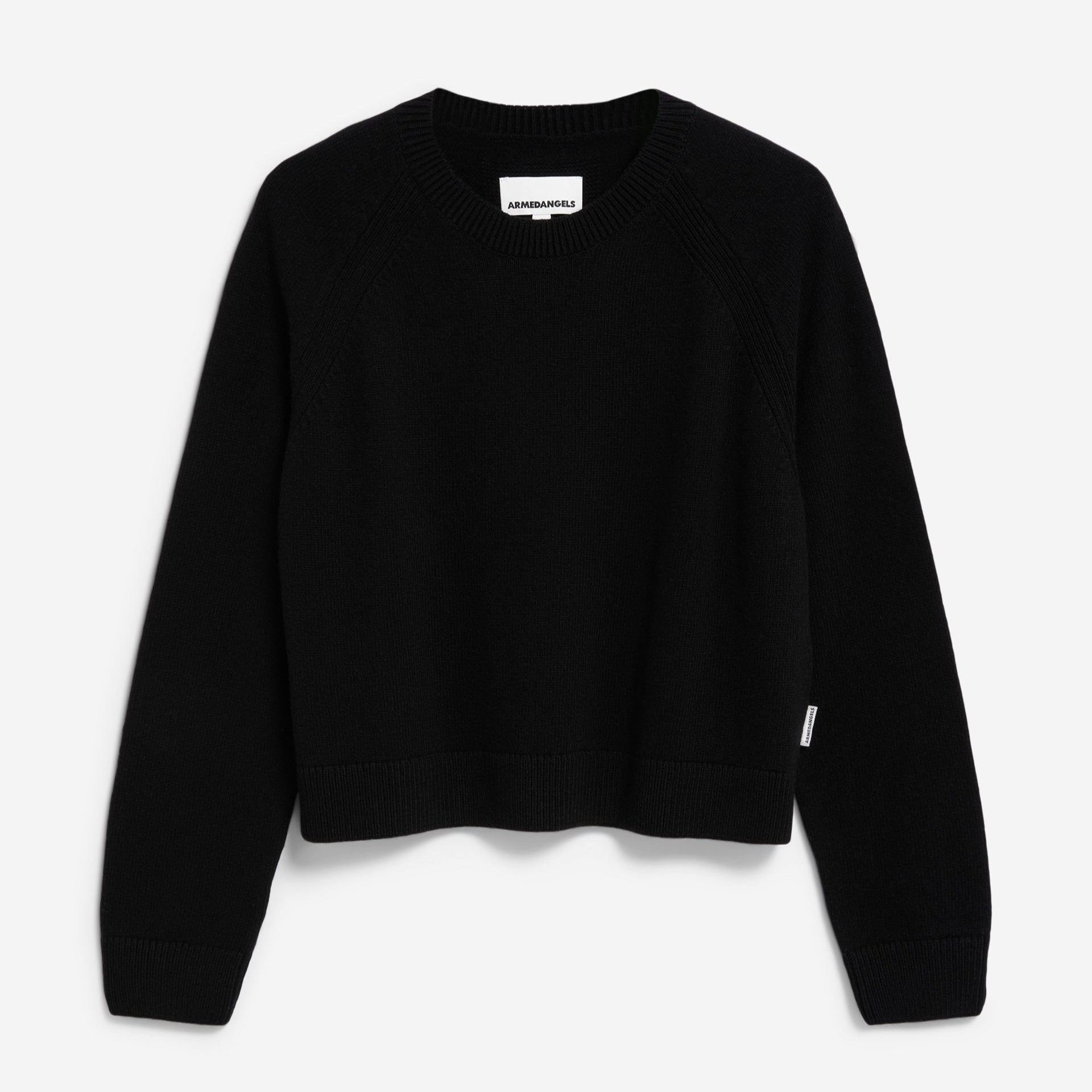 Ein schlichter, schwarzer, langärmeliger Strickpullover mit Rundhalsausschnitt, gerippten Bündchen und leicht abgeschnittenem Saum auf weißem Grund.