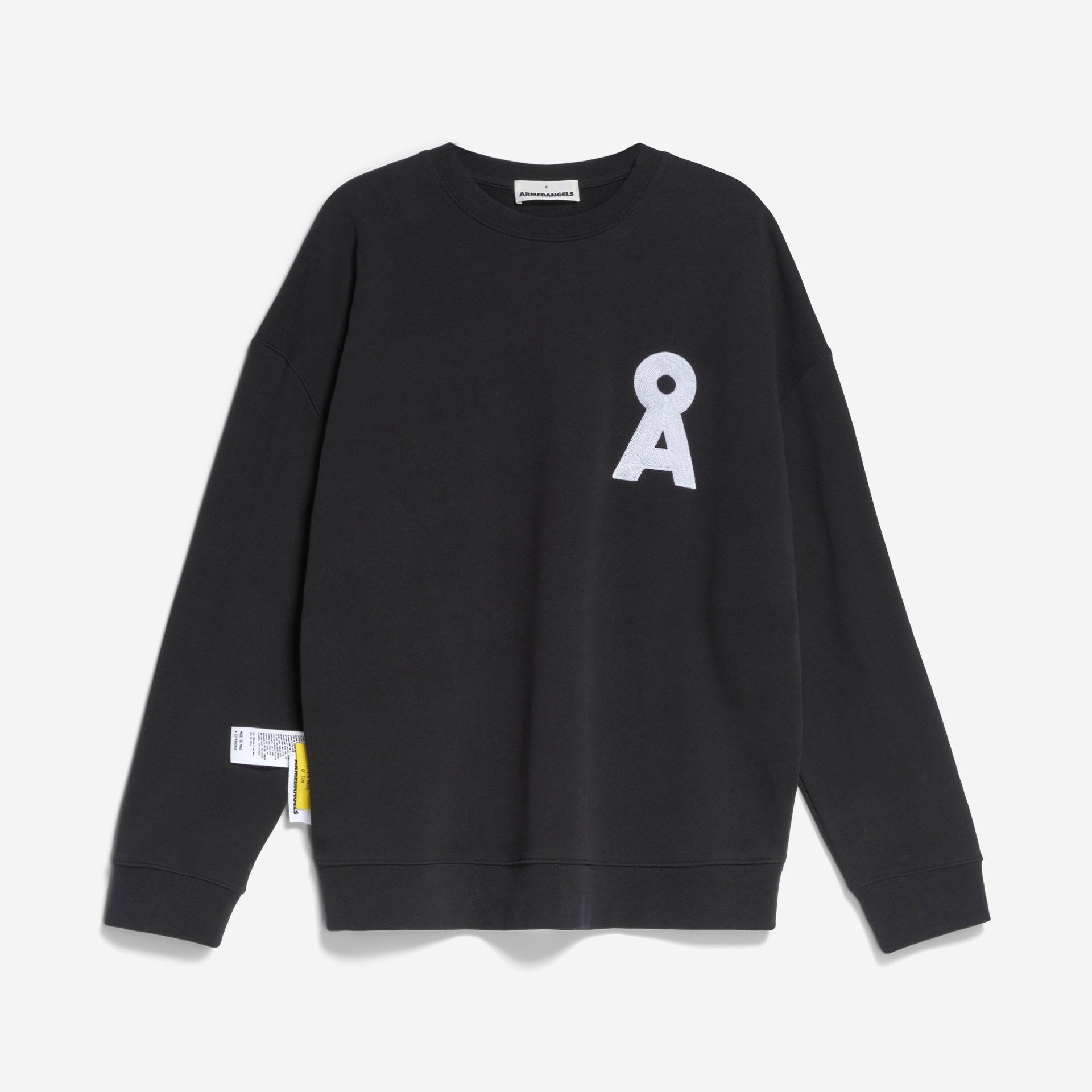 Ein schwarzes Sweatshirt mit Rundhalsausschnitt und weißer A-Applikation auf der linken Brust sowie einem kleinen weißen Etikett mit gelben Details auf der linken Seitennaht vor einem schlichten weißen Hintergrund.