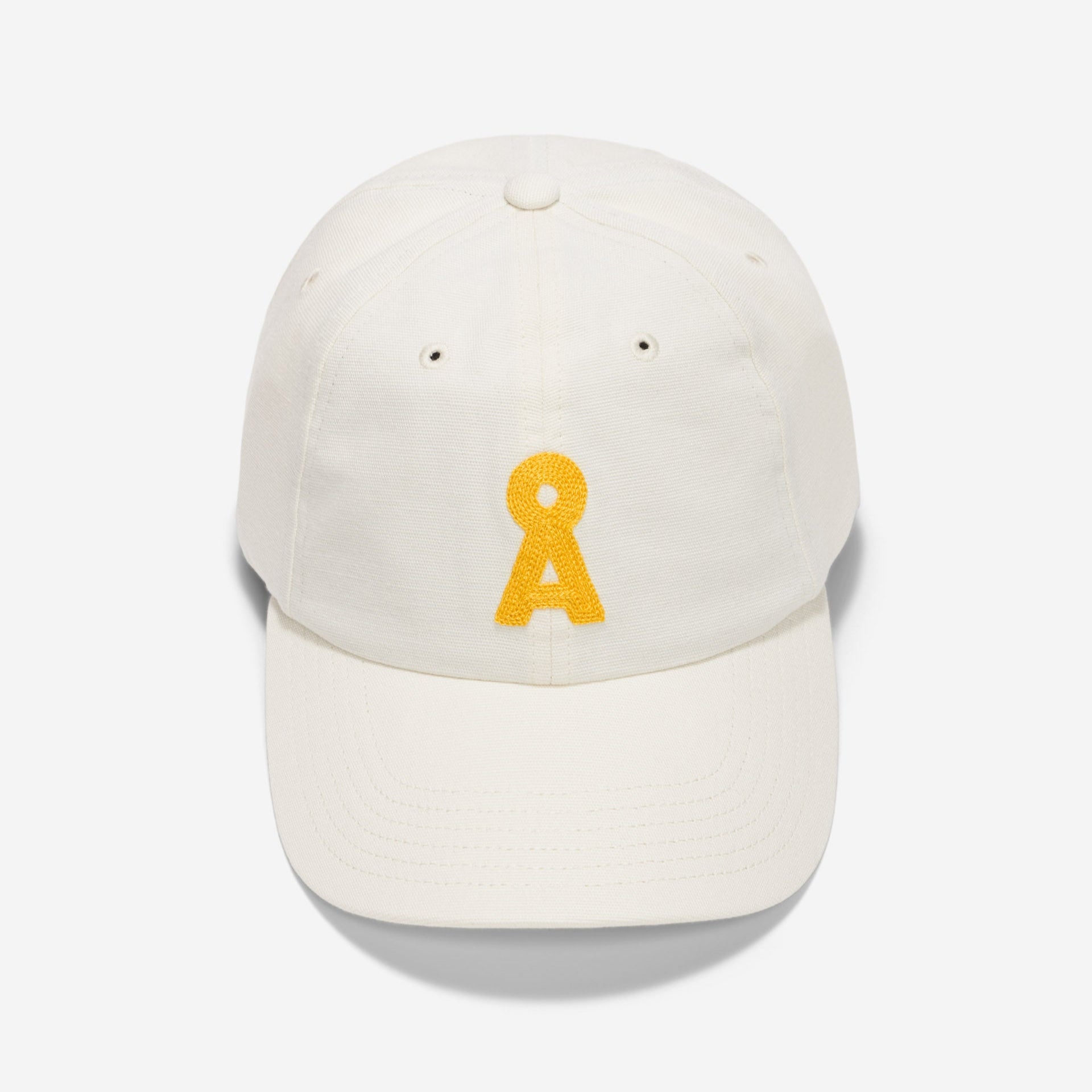 Eine weiße Baseballmütze mit einem gelben gestickten Schlüssellochmotiv auf der Vorderseite, das auf einem schlichten weißen Hintergrund abgebildet ist.