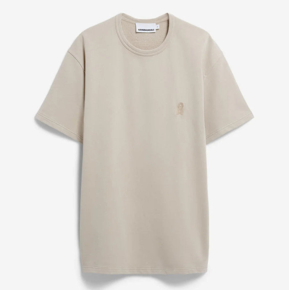 Ein schlichtes beigefarbenes Kurzarm-T-Shirt mit Rundhalsausschnitt auf weißem Grund. Das Shirt hat ein dezentes gesticktes Logo auf der linken Brust.
