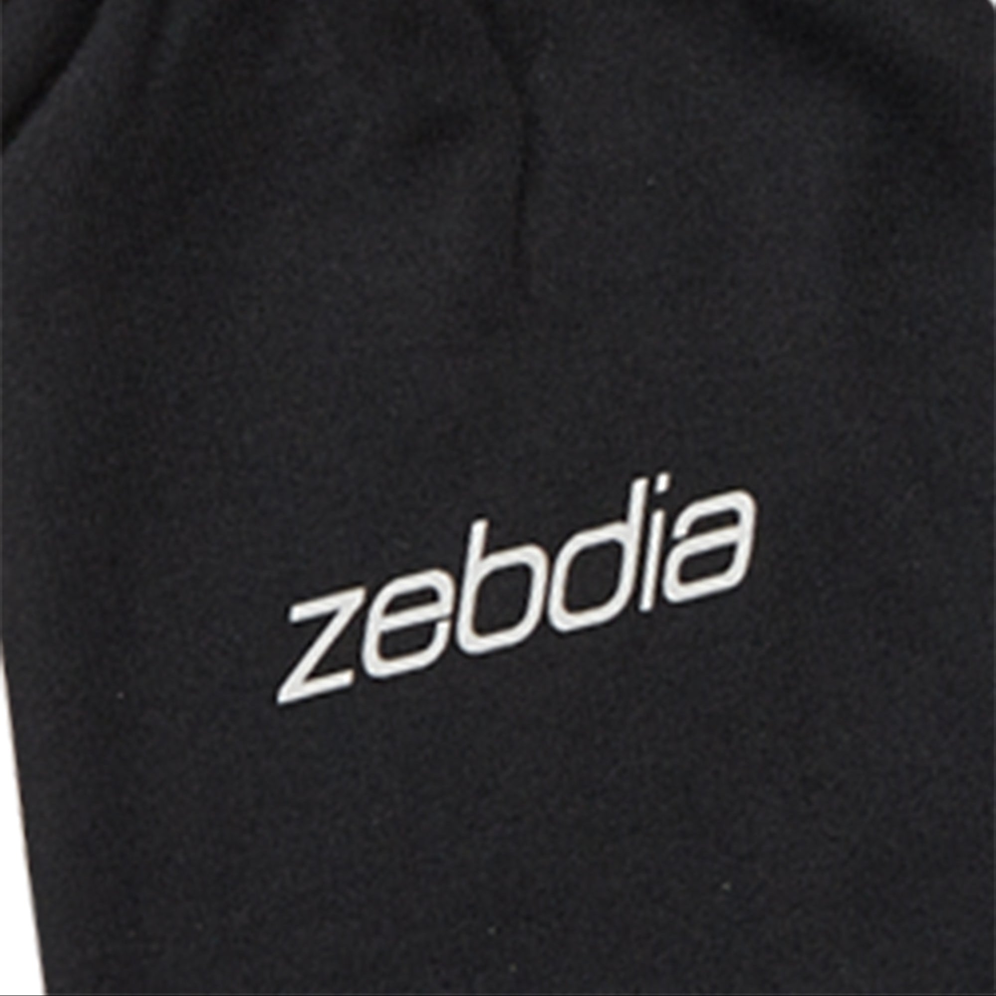 Nahaufnahme eines schwarzen Stoffes mit dem in weißen Kleinbuchstaben aufgedruckten Wort zebdia und einem in der Nähe des oberen Randes sichtbaren elastischen Saum.