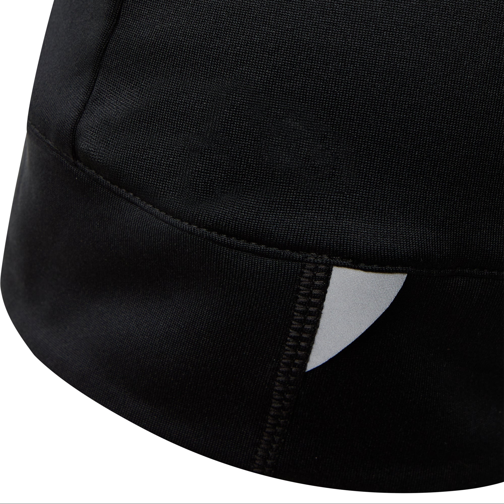 Nahaufnahme eines schwarzen Stoffstücks, möglicherweise Kleidung, mit einer Naht und einem kleinen weißen dreieckigen Detail in der Nähe des Saums.