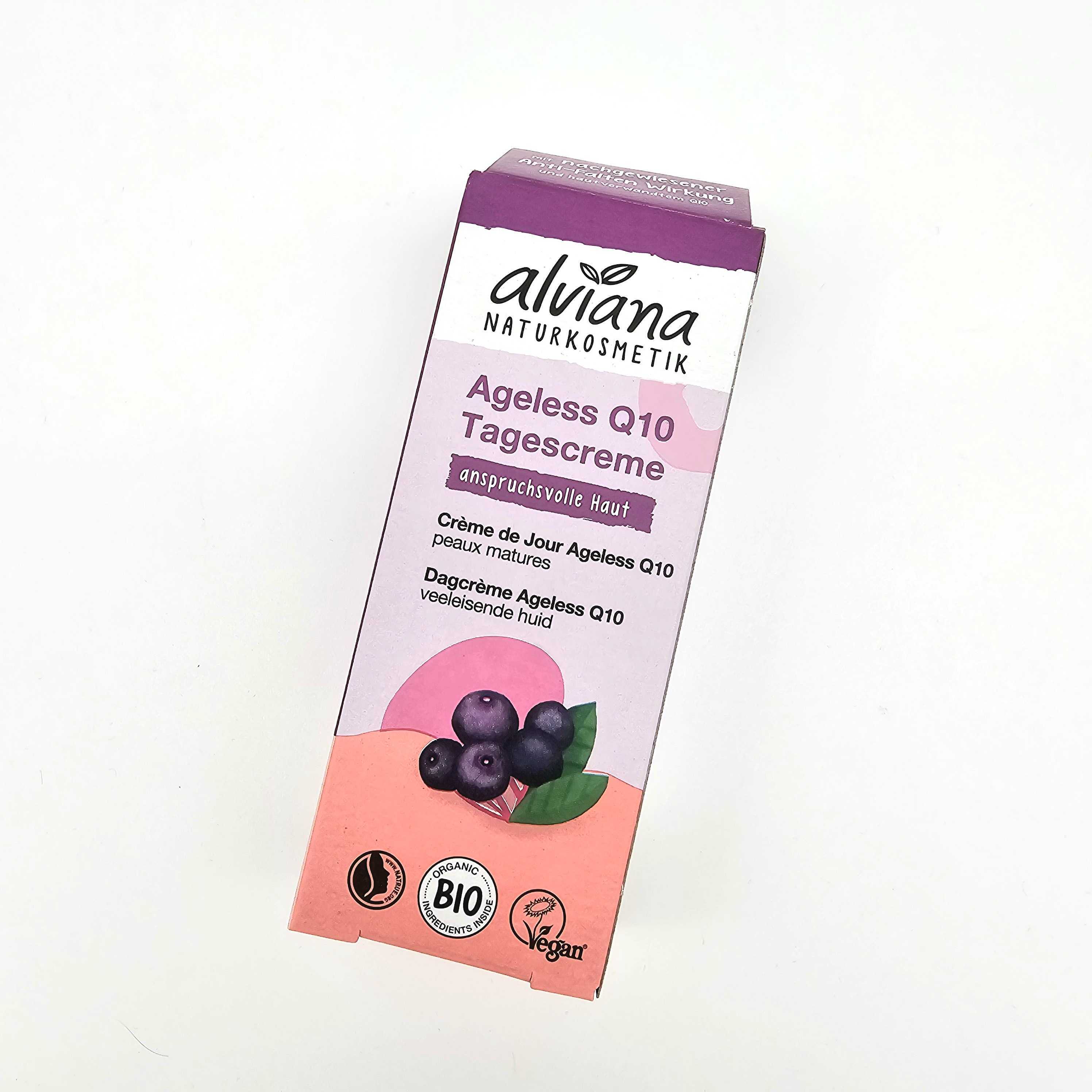 Eine rechteckige Schachtel der Alviana Naturkosmetik Ageless Q10 Tagescreme, mit lila und rosa Farben, einer Beeren-Illustration und Etiketten für Bio, vegan und reife Haut. Der Text ist auf Deutsch.
