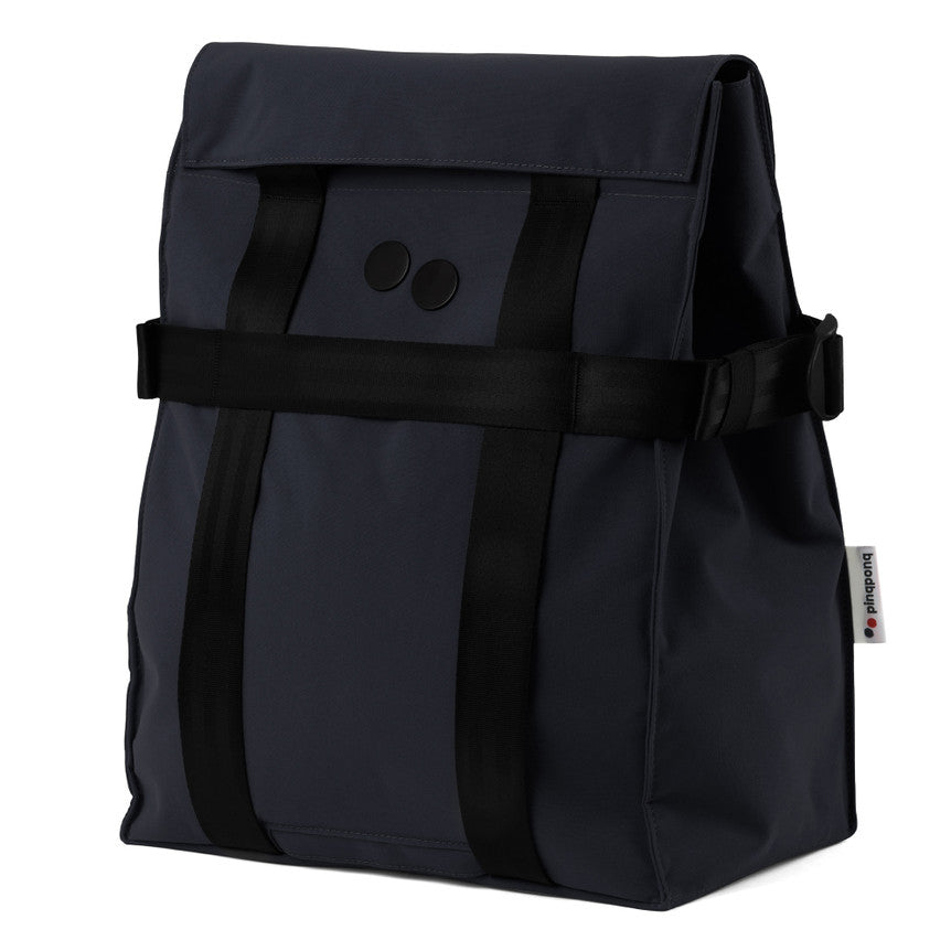 Dunkelgrauer, rechteckiger Rucksack mit schwarzen vertikalen Trägern und zwei schwarzen, runden Knöpfen auf der Vorderseite. Die Tasche hat ein minimalistisches Design und ein Stoffschild an der Seite.