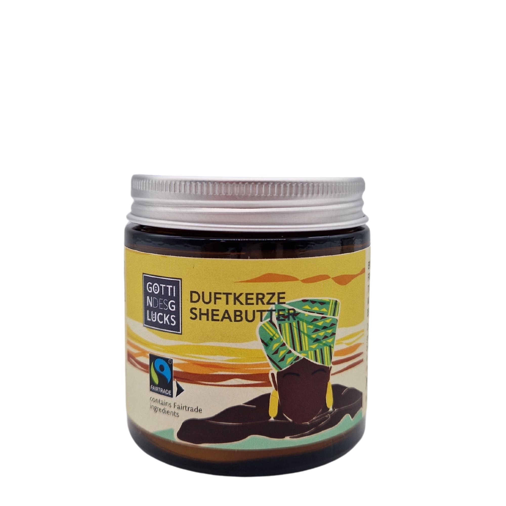 Ein Glas mit der Aufschrift Göttin des Glücks Duftkerze Sheabutter mit der Abbildung einer Person, die eine bunte Kopfbedeckung trägt, auf gelbem Hintergrund. Das Etikett enthält das Fairtrade-Logo.