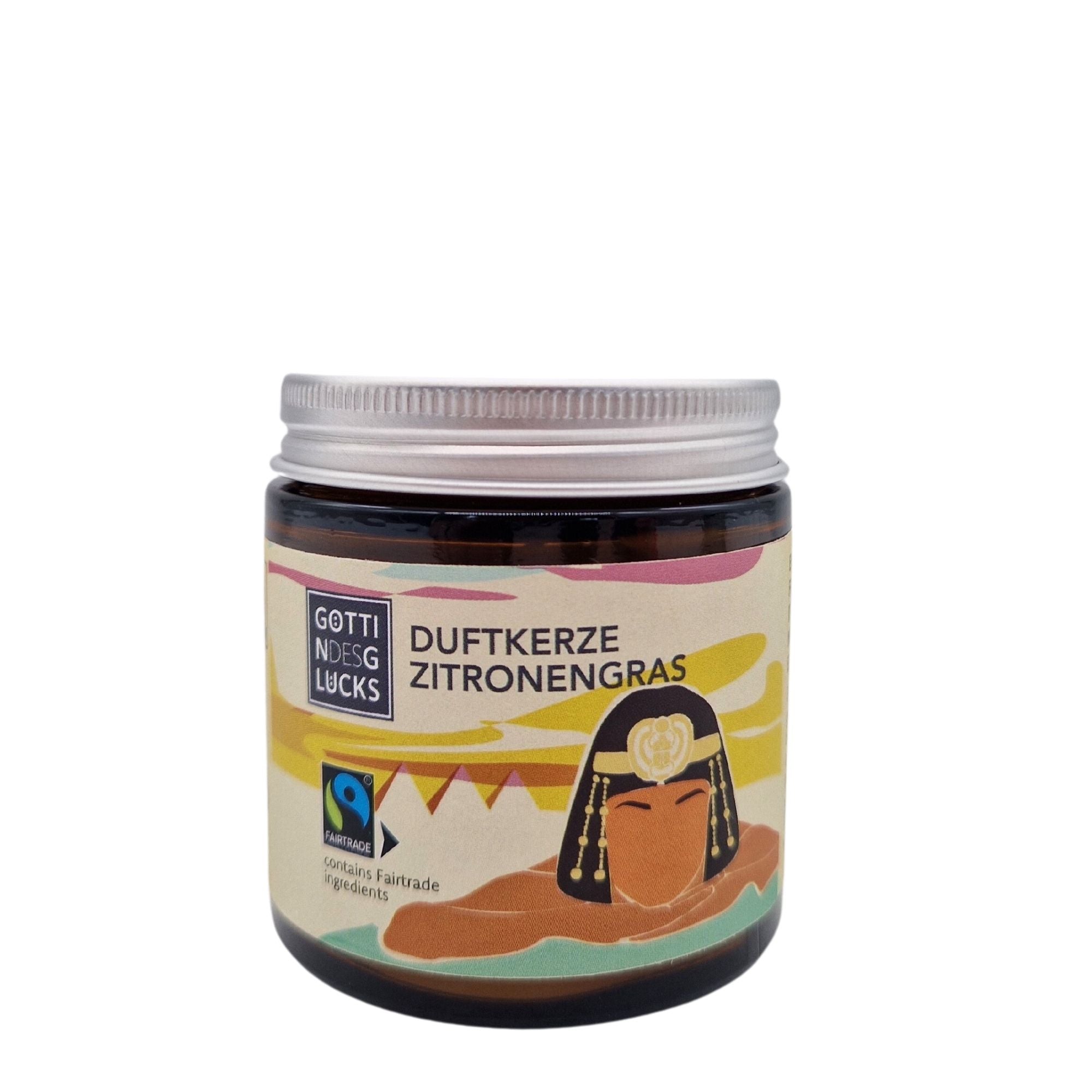 Eine Kerze in einem Glas mit der Aufschrift Duftkerze Zitronengras und der farbenfrohen Darstellung einer altägyptischen Frau, einer Wimpelkette und dem Logo der Fairtrade-Zertifizierung auf der Vorderseite. Das Glas hat einen silbernen Schraubdeckel.