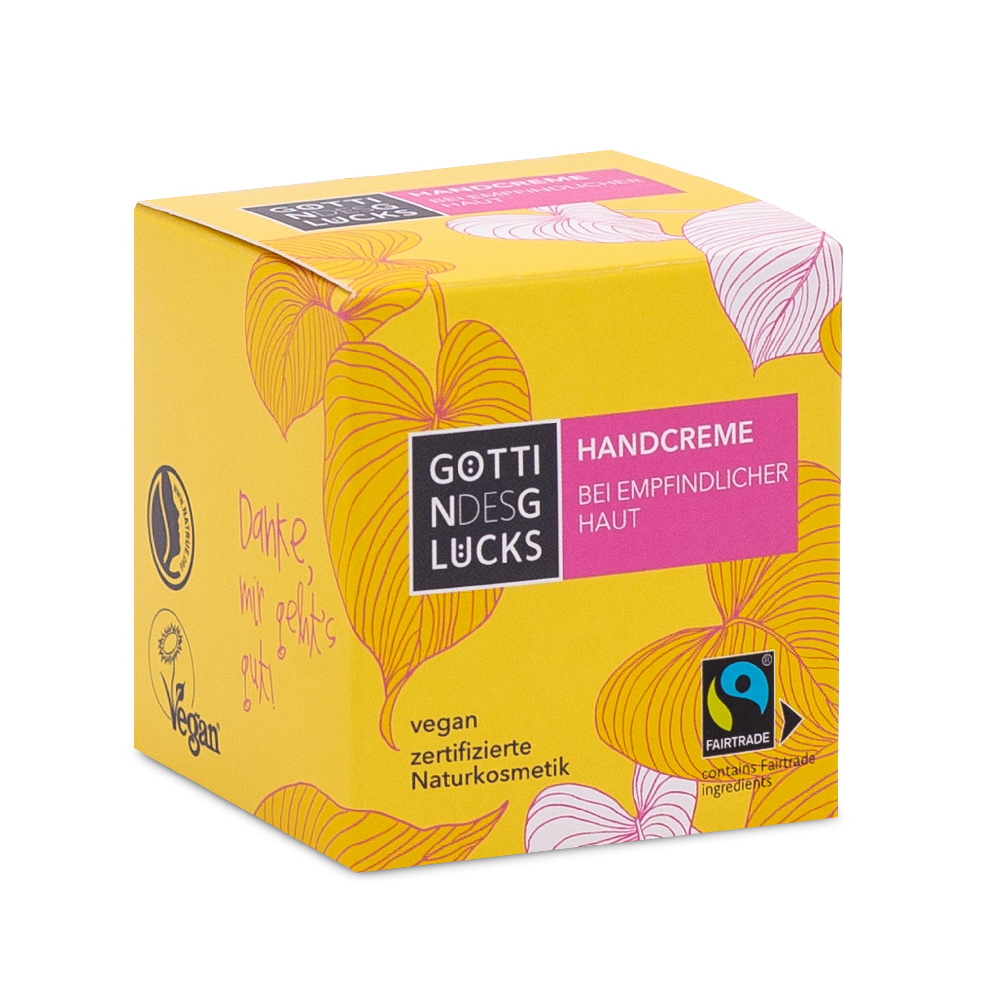 Eine gelbe Schachtel mit GOTTI NDESGLUCKS Handcreme für empfindliche Haut mit rosa und orangefarbenen Blattillustrationen, Fairtrade- und Vegan-Zertifizierungslogos sowie Produktinformationen in deutscher Sprache.
