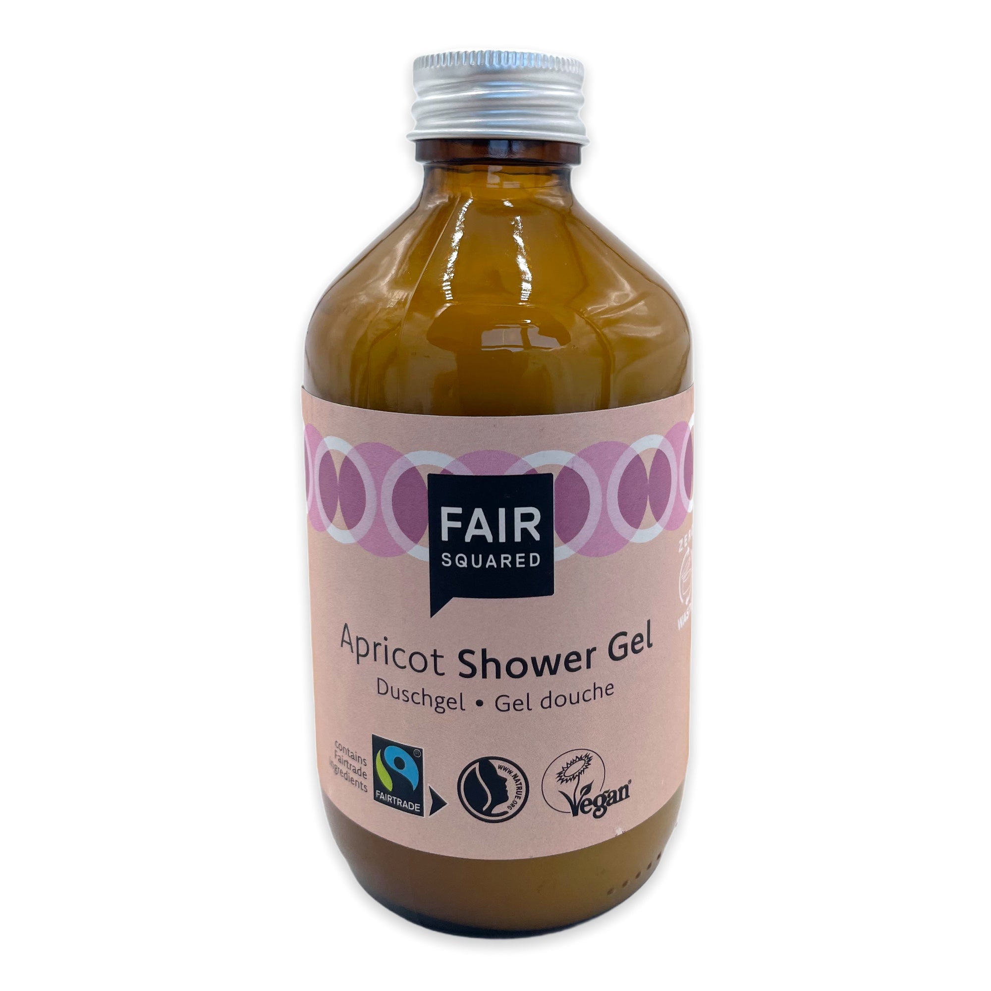 Eine braune Flasche Fair Squared Apricot Duschgel mit einer silbernen Kappe und einem rosa Etikett mit Fairtrade- und Vegan-Zertifizierungslogos.