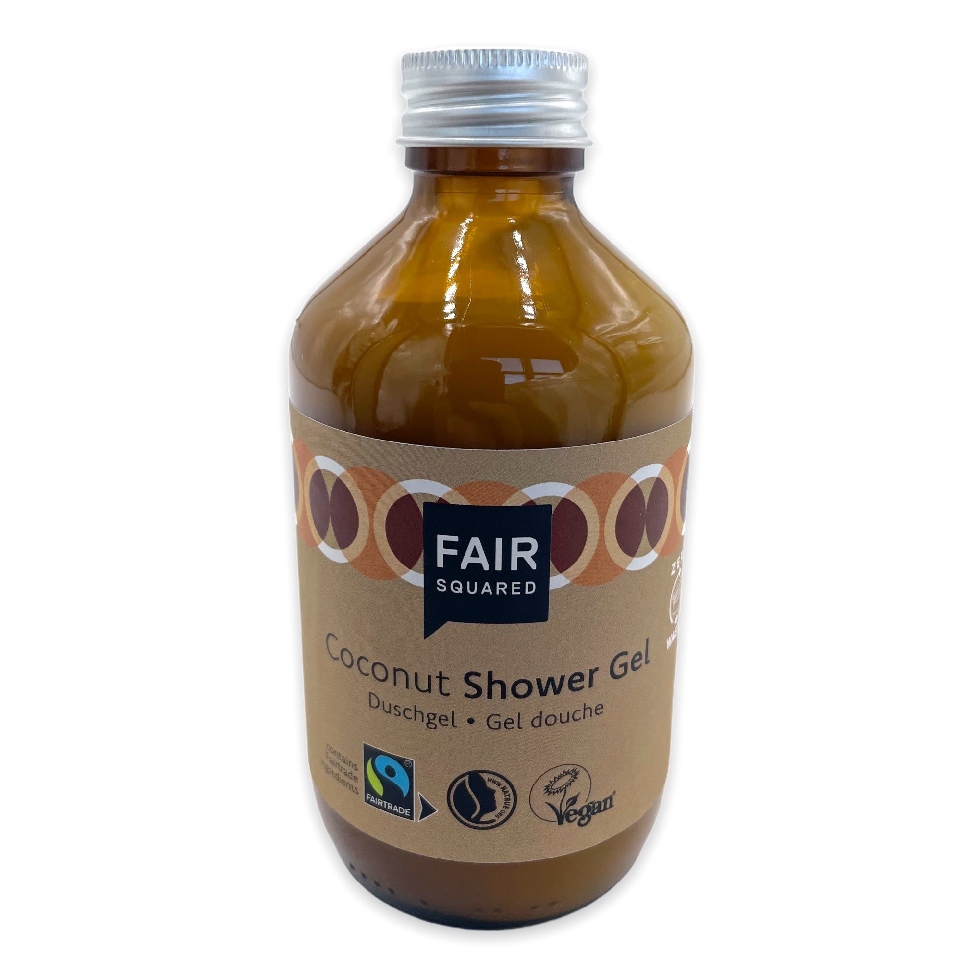 Eine braune Glasflasche mit Fair Squared Coconut Shower Gel und einer silbernen Kappe. Das Etikett ist beige mit kreisförmigen Mustern und zeigt Fairtrade-, Vegan- und Halal-Zertifizierungslogos.