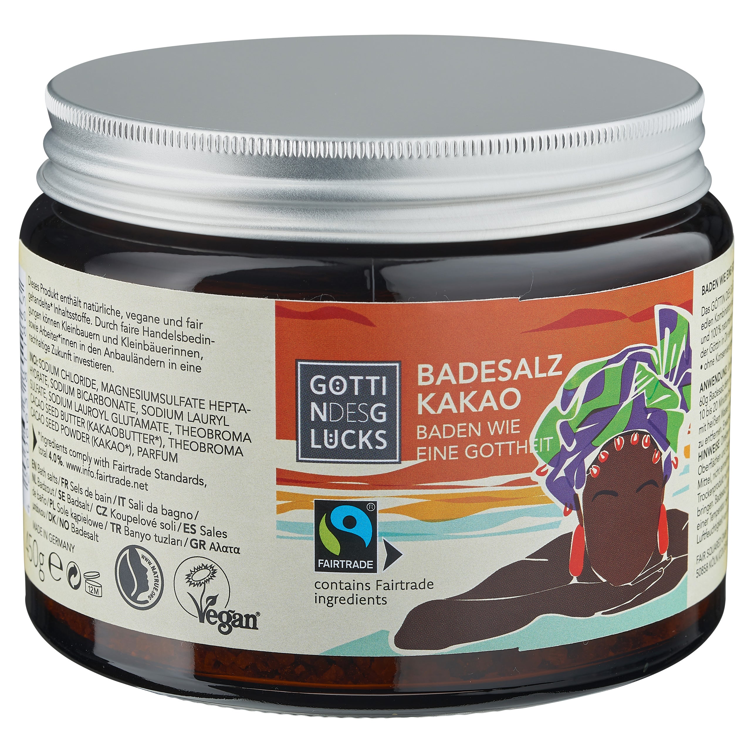 Ein Glas "Göttin des Glücks Badesalz Kakao" mit einem farbenfrohen Etikett, das eine illustrierte Frau mit Kopfbedeckung zeigt. Auf dem Glas befinden sich vegane und Fairtrade-Logos sowie Produktangaben auf Deutsch.