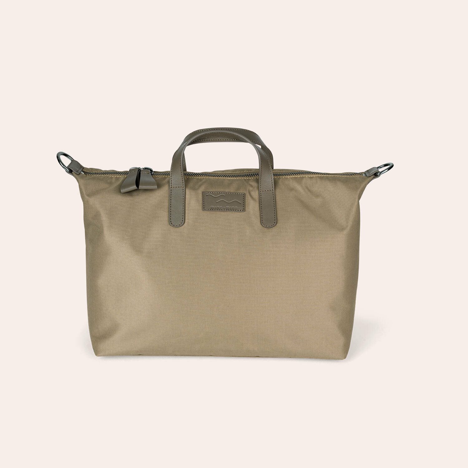 Eine khakifarbene Tragetasche mit kurzen Henkeln, einem Reißverschluss und einem dezenten rechteckigen Logoaufnäher auf der Vorderseite, der vor einem schlichten hellen Hintergrund steht.