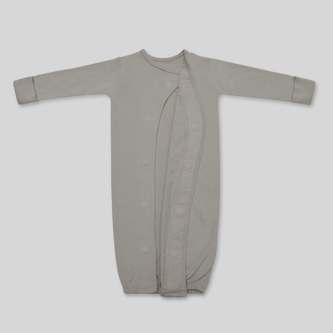 Grauer Baby-Schlafsack mit langen Ärmeln und durchgehender Knopfleiste auf hellem Hintergrund.