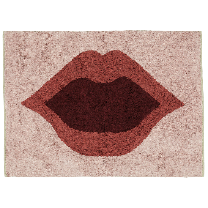 Eine rechteckige, hellrosa Badematte mit einer großen Illustration roter Lippen mit einem offenen Mund in der Mitte.
