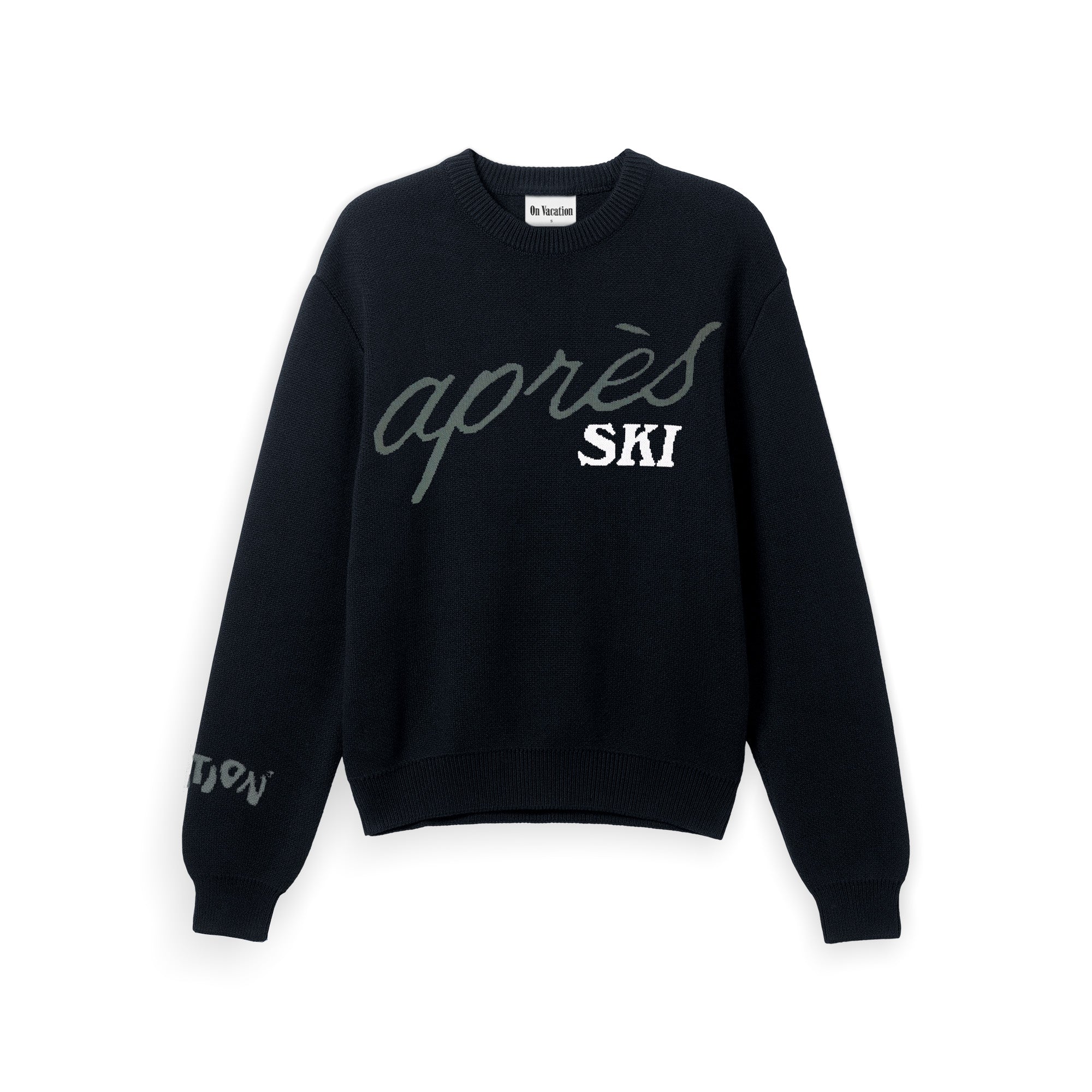 Ein schwarzer Pullover mit Rundhalsausschnitt und dem Schriftzug après SKI in großen, stilisierten Buchstaben auf der Vorderseite und einer kleineren Schrift auf dem linken Ärmel.