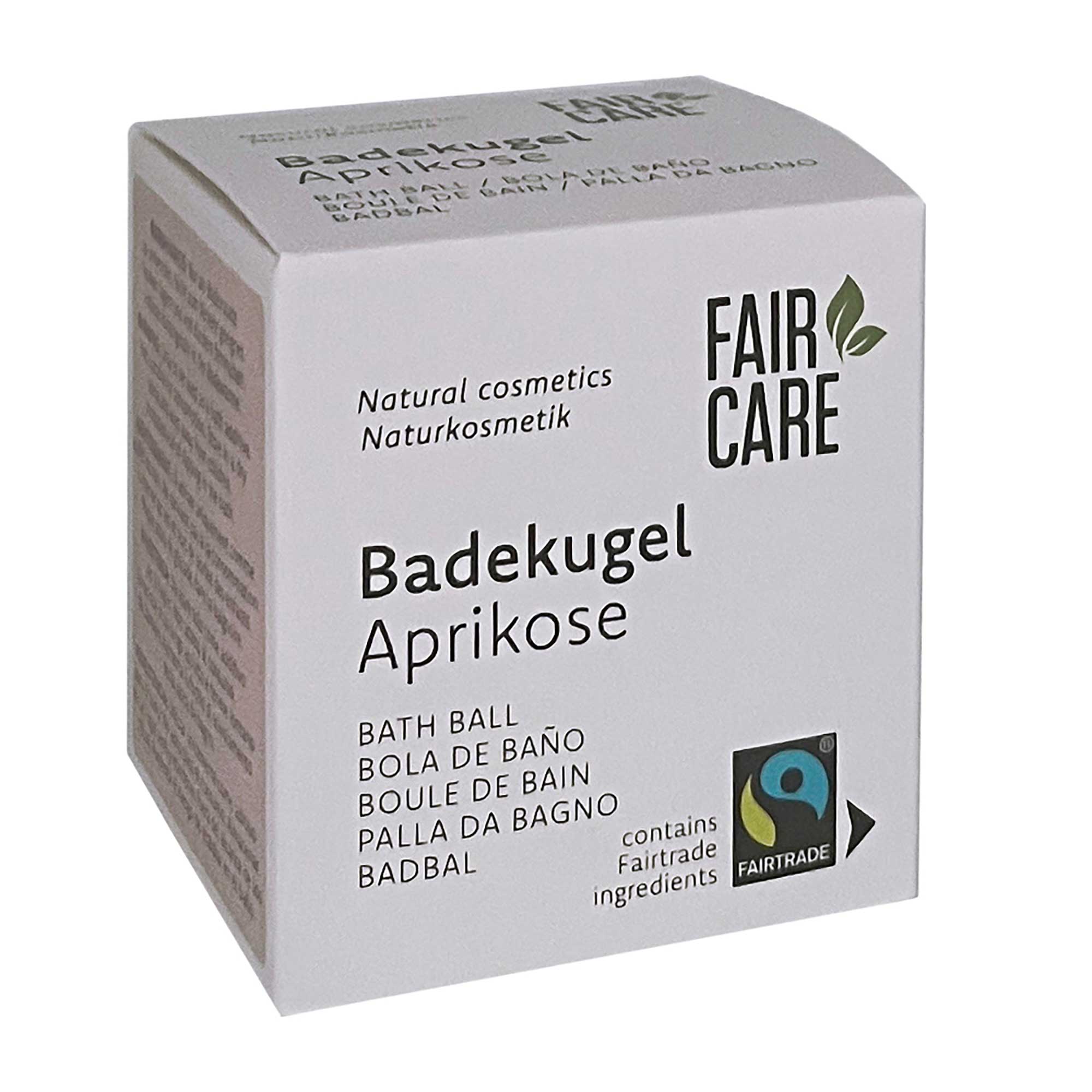 Eine Schachtel Fair Care Badekugel mit Aprikosenduft, mehrsprachig etikettiert, mit Fairtrade-Zertifizierung und einem Hinweis auf Naturkosmetik und fair gehandelte Inhaltsstoffe. Die Schachtel ist weiß mit schwarzem und grünem Text.