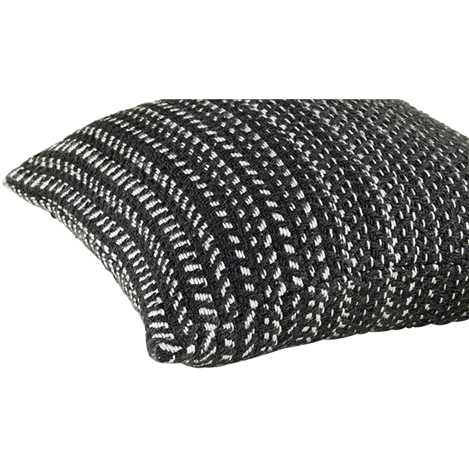 Eine Nahaufnahme eines rechteckigen Kissens mit einem strukturierten, gewebten Muster in Schwarz und Weiß. Das Kissen wirkt weich und ist vor einem schlichten weißen Hintergrund platziert.