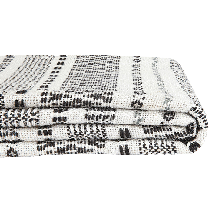 Eine gefaltete weiße Decke mit einem schwarz-grauen gewebten Muster mit horizontalen und vertikalen Linien auf einem schlichten weißen Hintergrund.