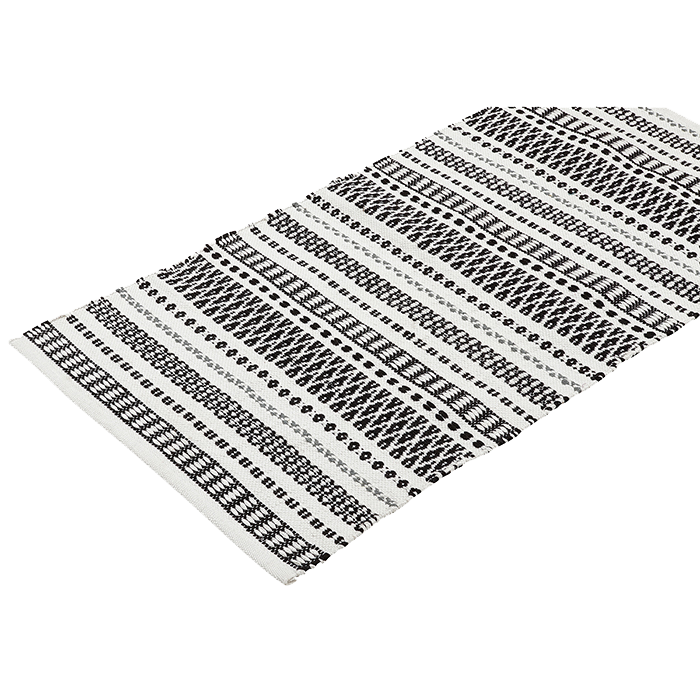 Ein rechteckiger, schwarz-weißer Webteppich mit einem sich wiederholenden Muster aus geometrischen Streifen und Formen auf weißem Hintergrund.