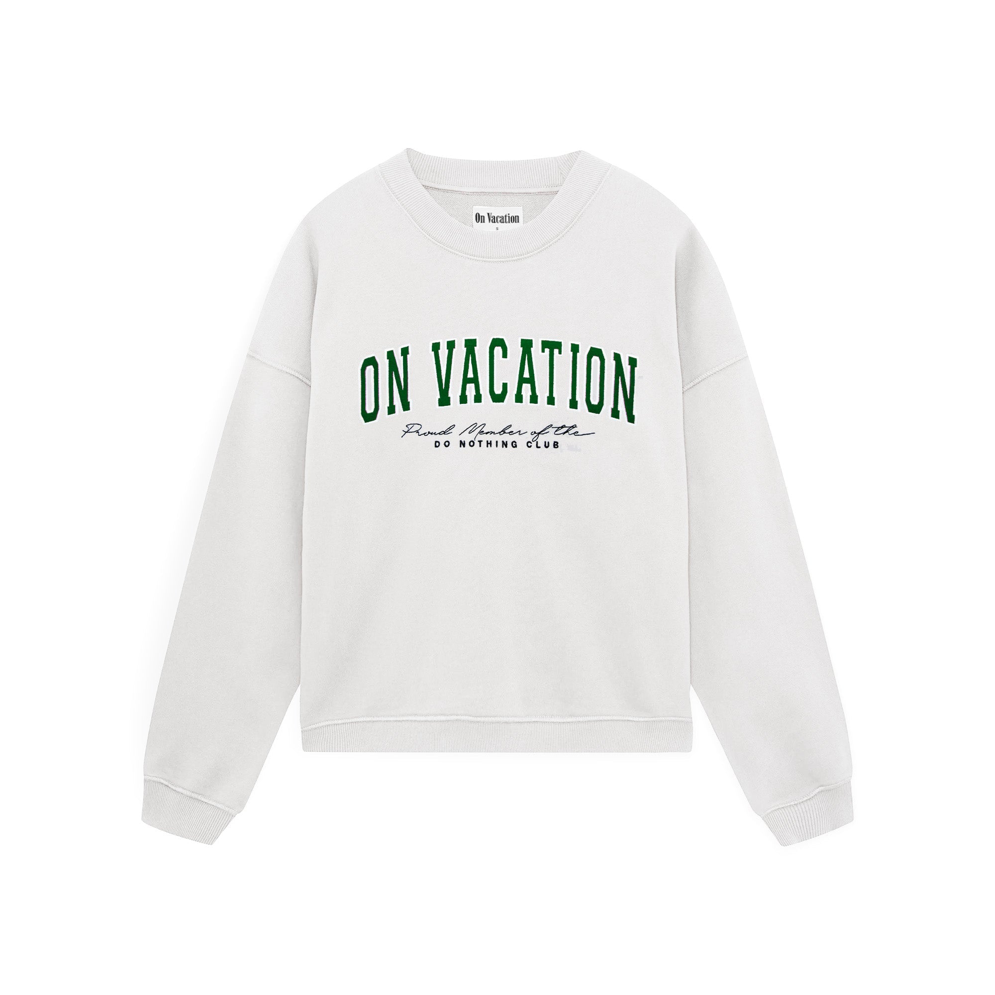 Ein weißes Sweatshirt mit Rundhalsausschnitt und dem Aufdruck ON VACATION in großen grünen Buchstaben auf der Vorderseite, darunter in kleinerer schwarzer Schrift und dem Schriftzug DO NOTHING CLUB.